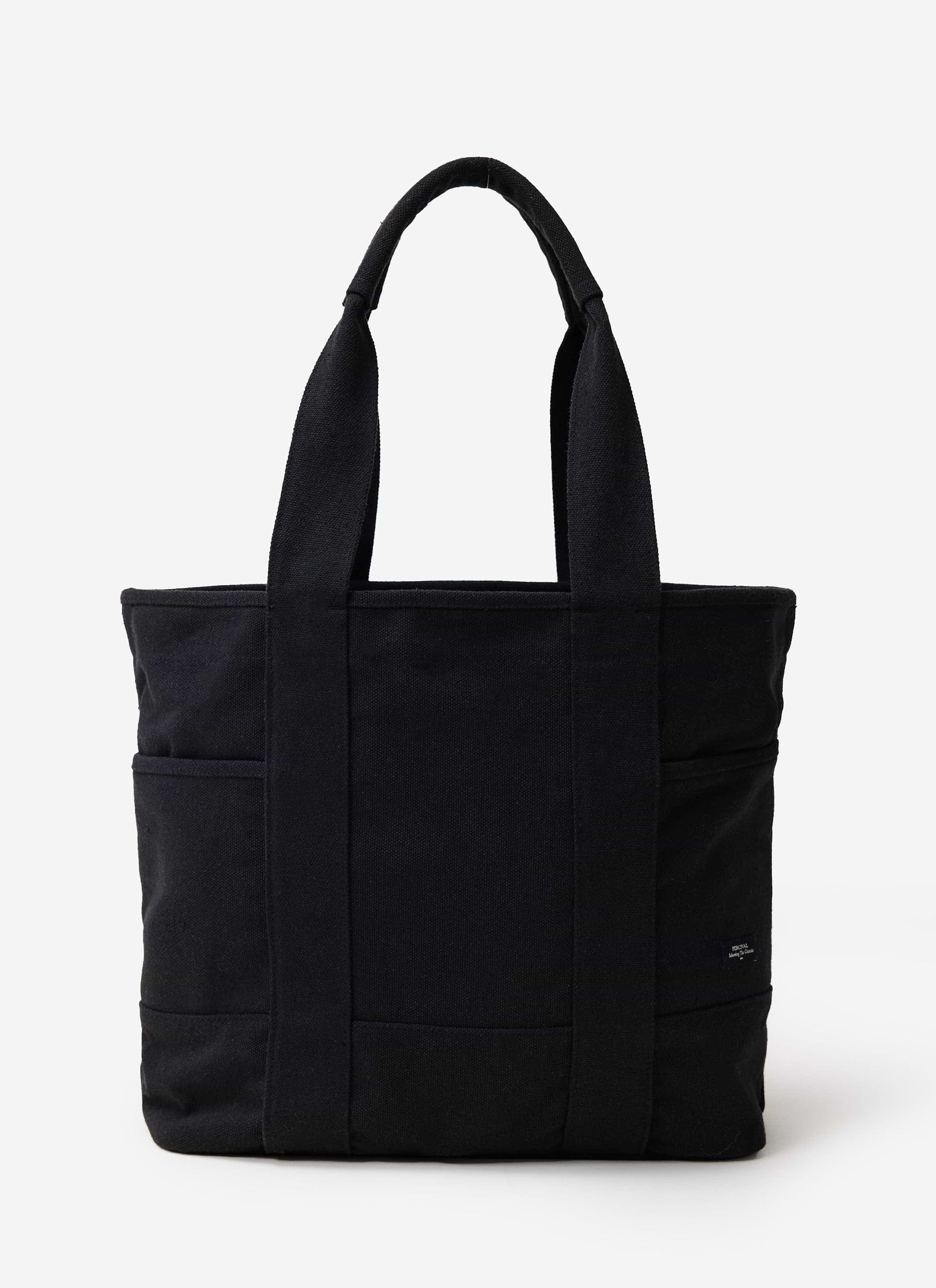The Percival Tote Bag in black heavy-weight canvas, featuring sturdy handles and external pockets, shot in a studio.