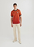 red football shirt with diamond shapes styled with ecru trousers and converse