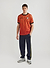 red football shirt with diamond shapes styled with navy jacquard track pants and sneakers