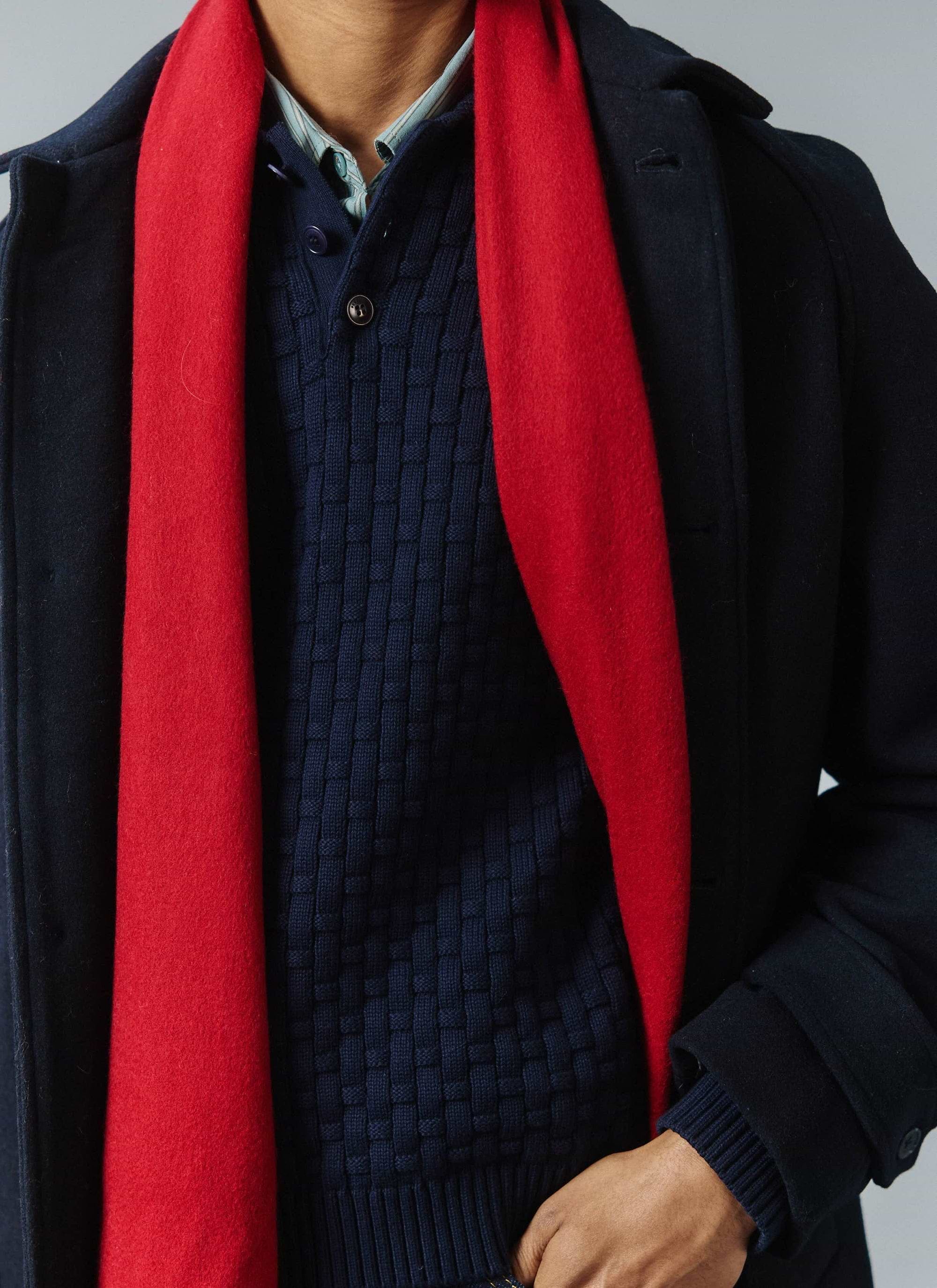 A close-up of a model wearing the Percival navy wool car coat layered with the vibrant red Tolkein scarf.