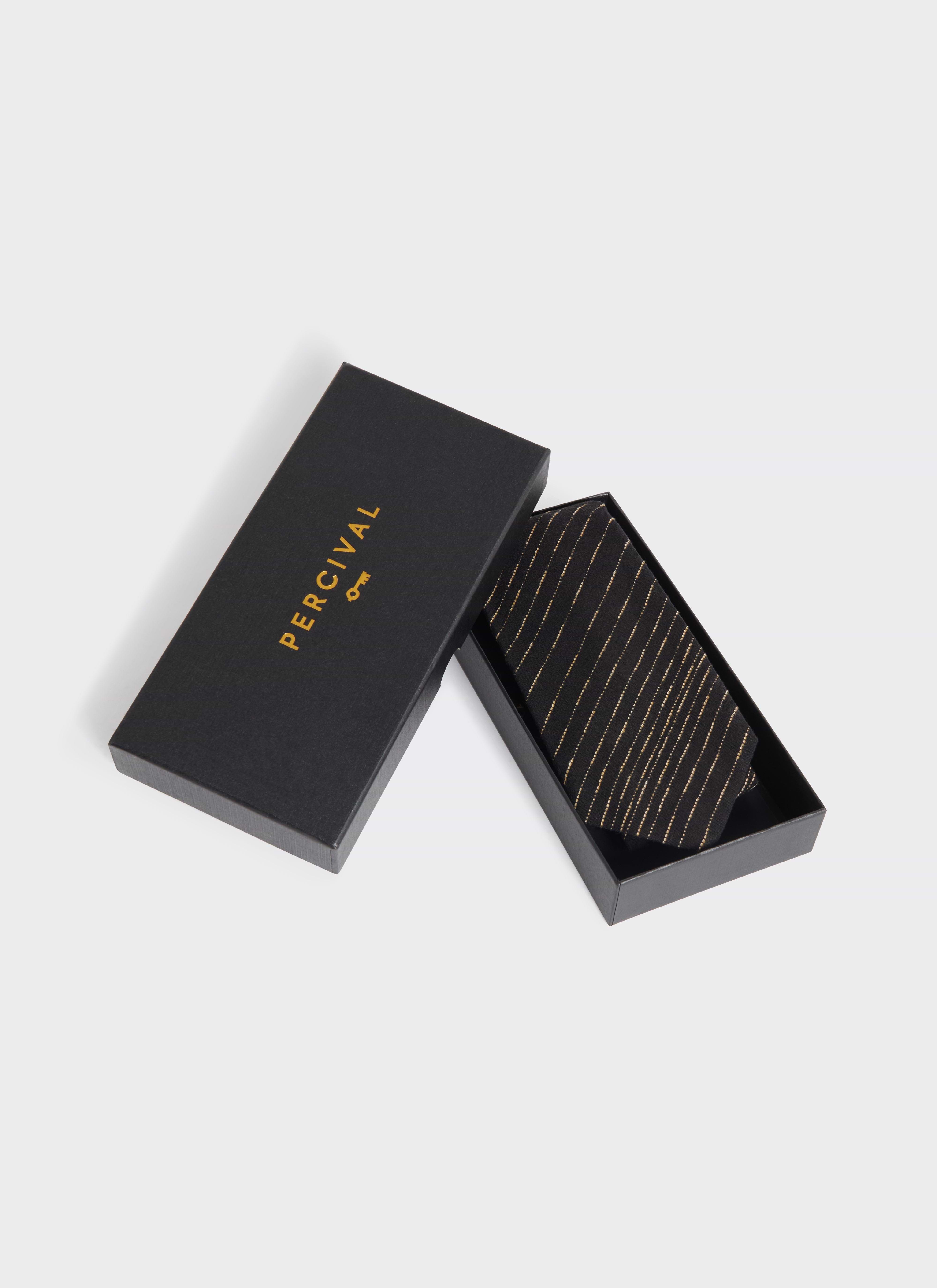The Percival Leland Tie in black cotton with gold stripes, presented in its branded black gift box.