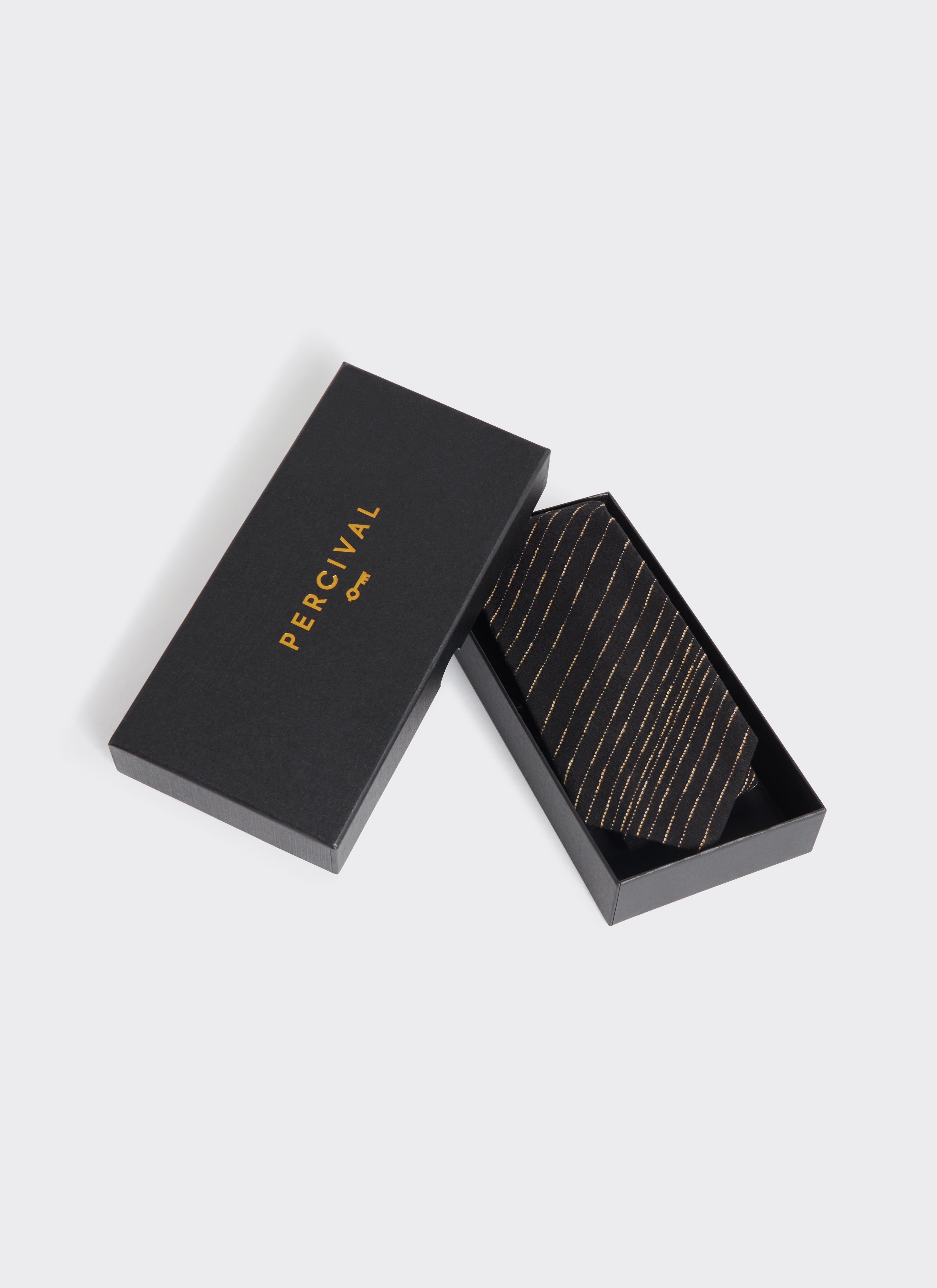 The Percival Leland Tie in black cotton with gold stripes, presented in its branded black gift box.