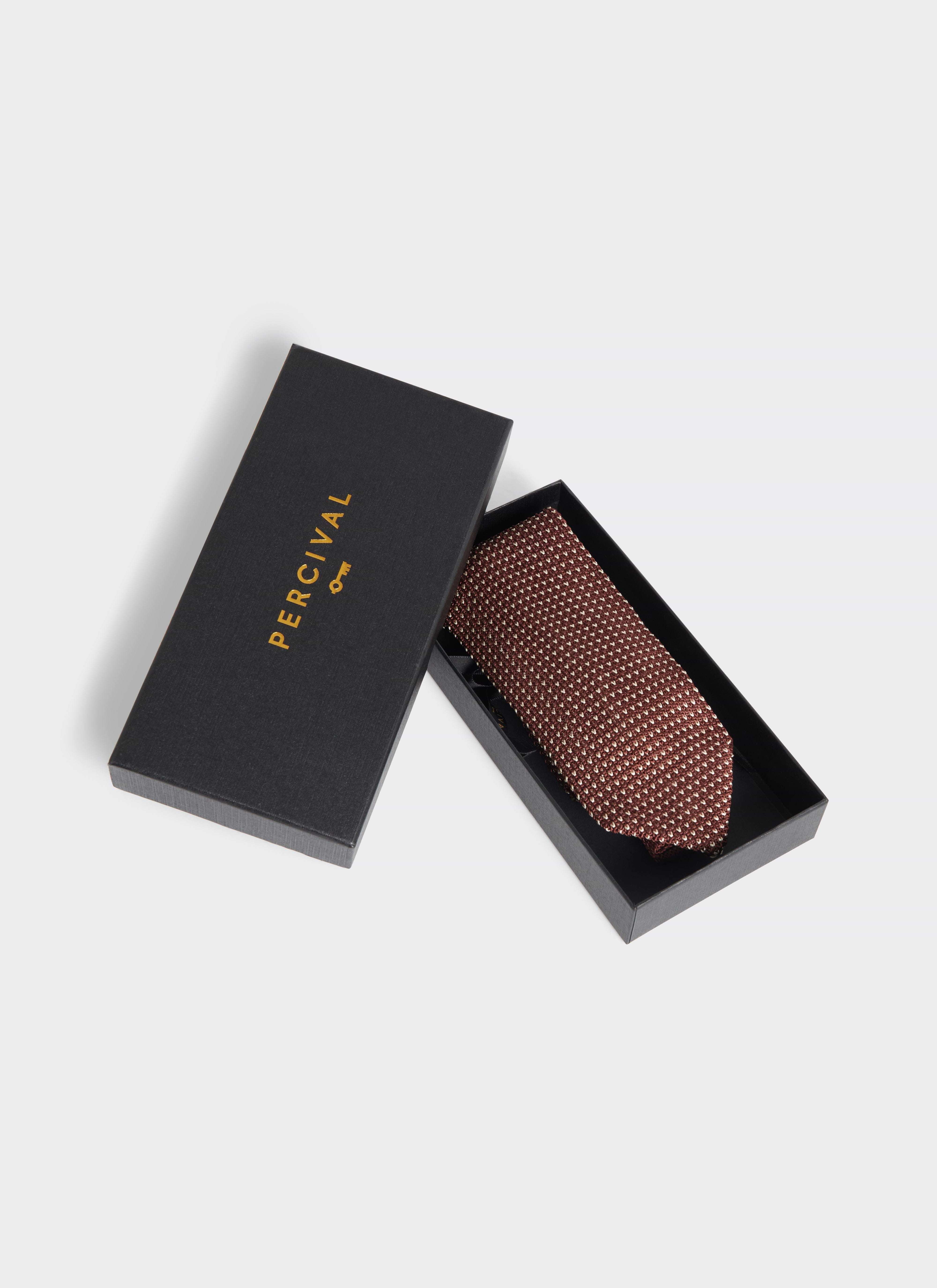 Percival espresso brown silk Birdseye Tie presented in a black branded gift box with a gold logo.