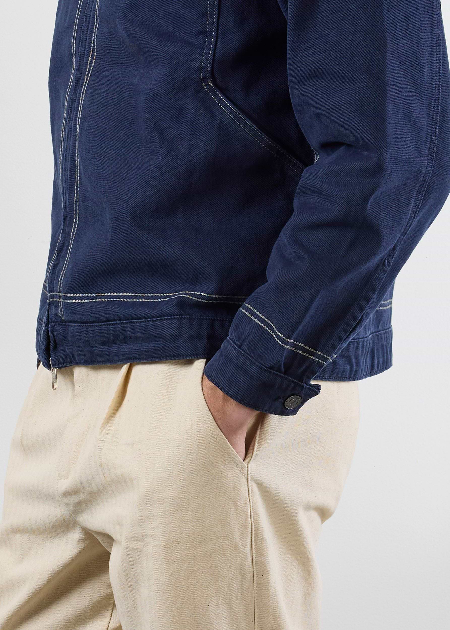 A side-view close-up of the Percival Calabria Harrington Jacket in navy, showing the contrast stitching and cotton texture.