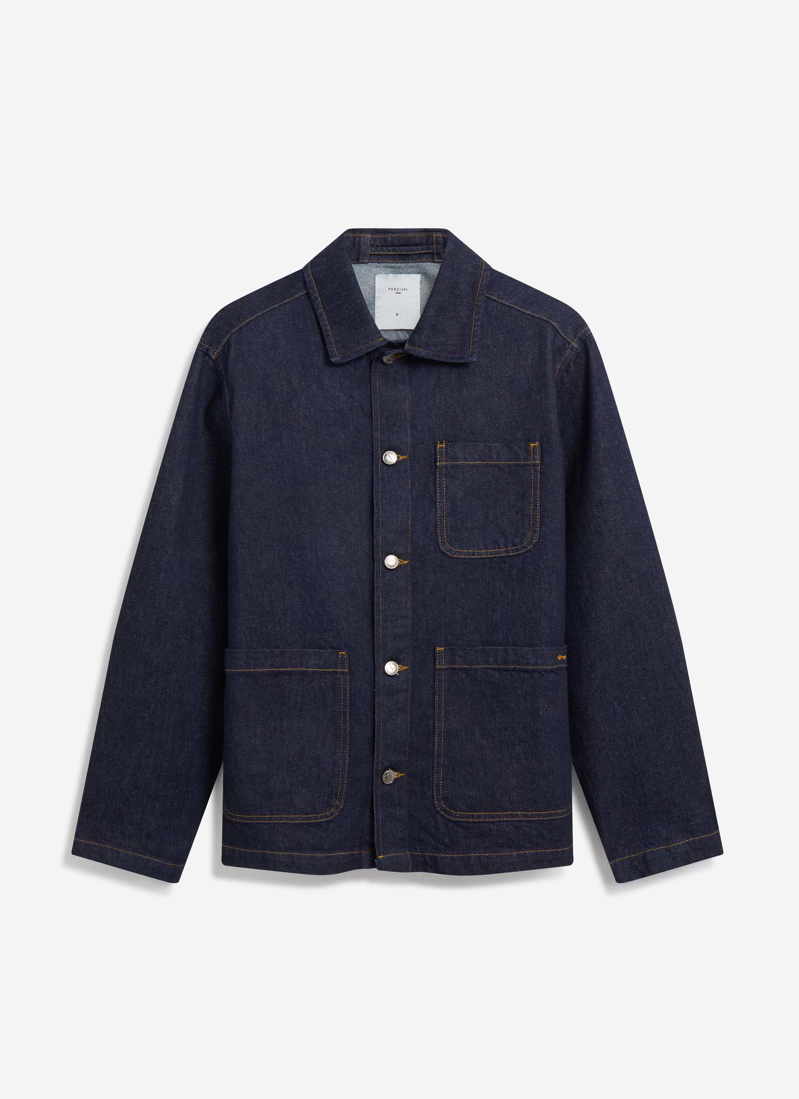The Percival Gove Chore Jacket in dark indigo denim, laid flat to show its classic cut, patch pockets and contrast stitching.