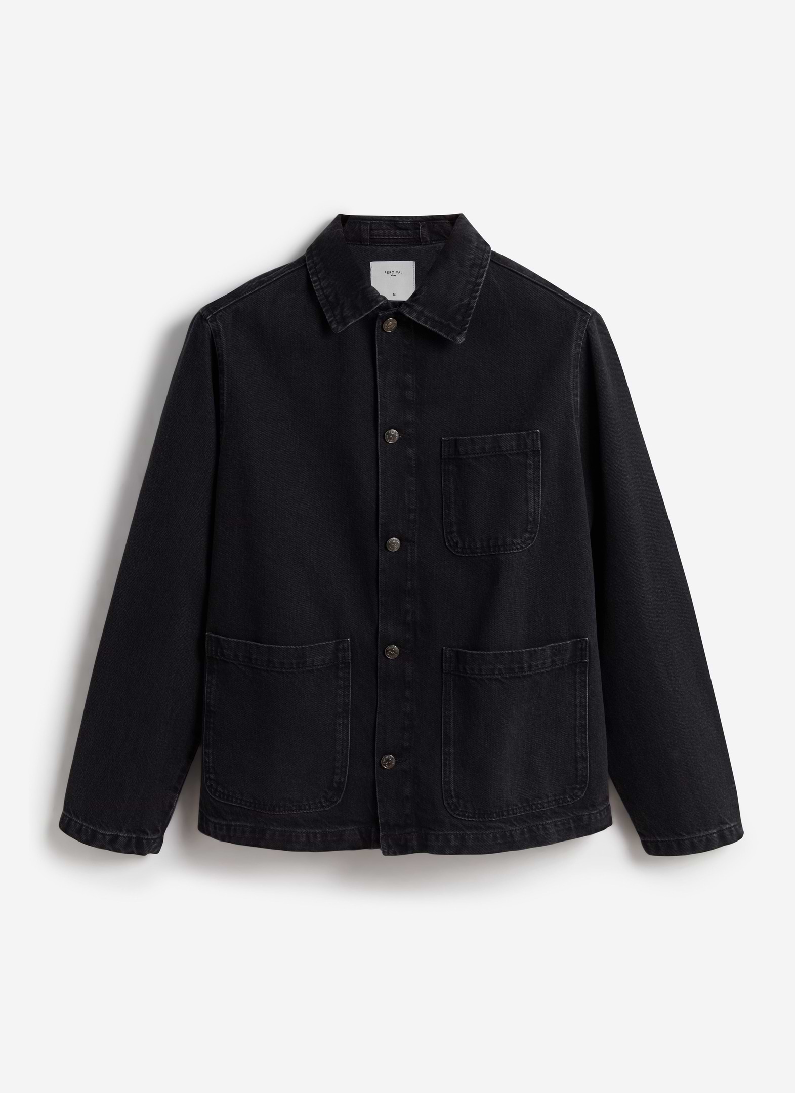 A flat lay of the Percival Gove Chore Jacket in black denim, showing its classic collar, buttons, and patch pockets.