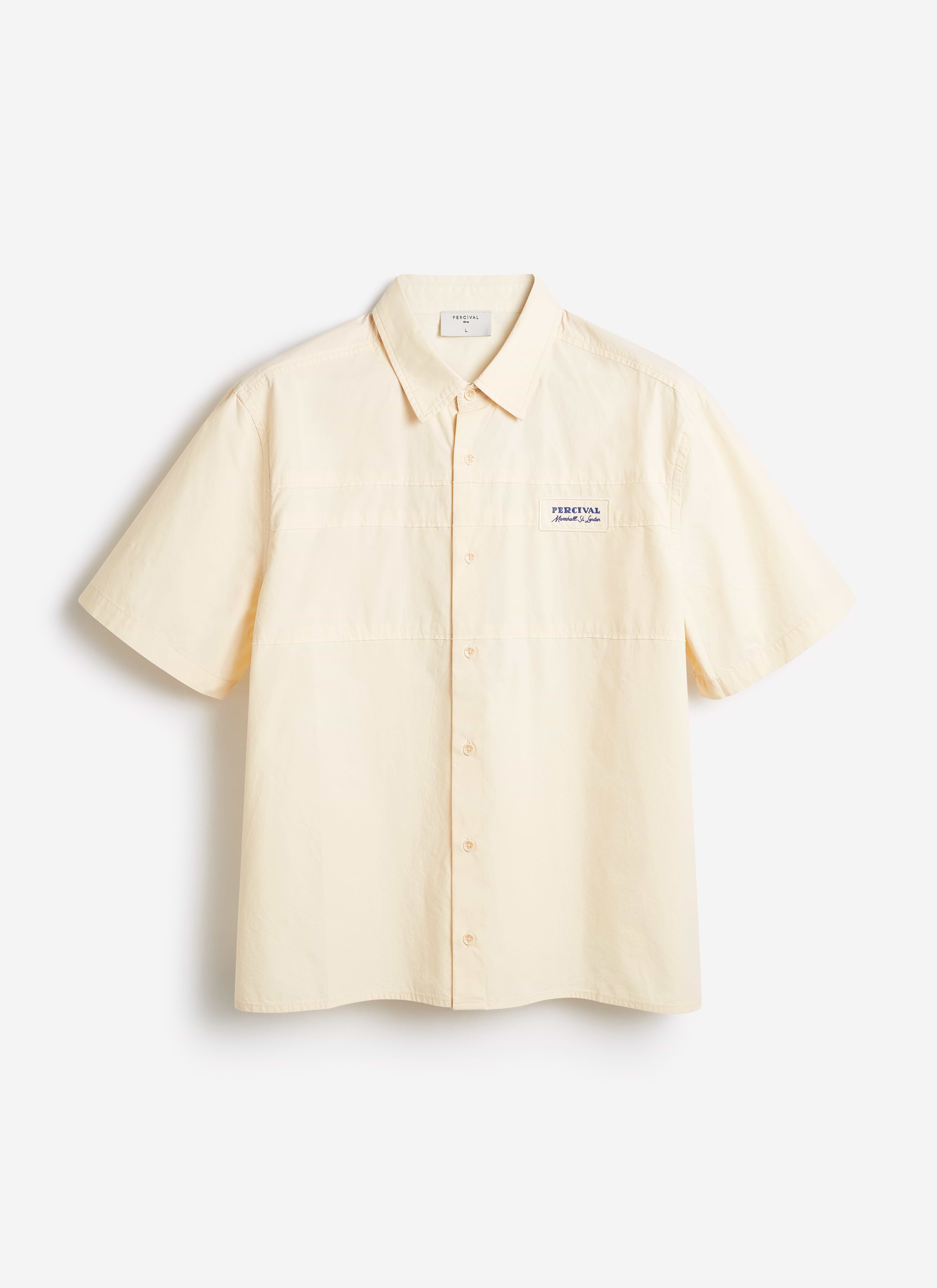 Percival Harlow Boxy Shirt in ecru cream cotton, featuring a short-sleeve relaxed fit and embroidered chest badge.
