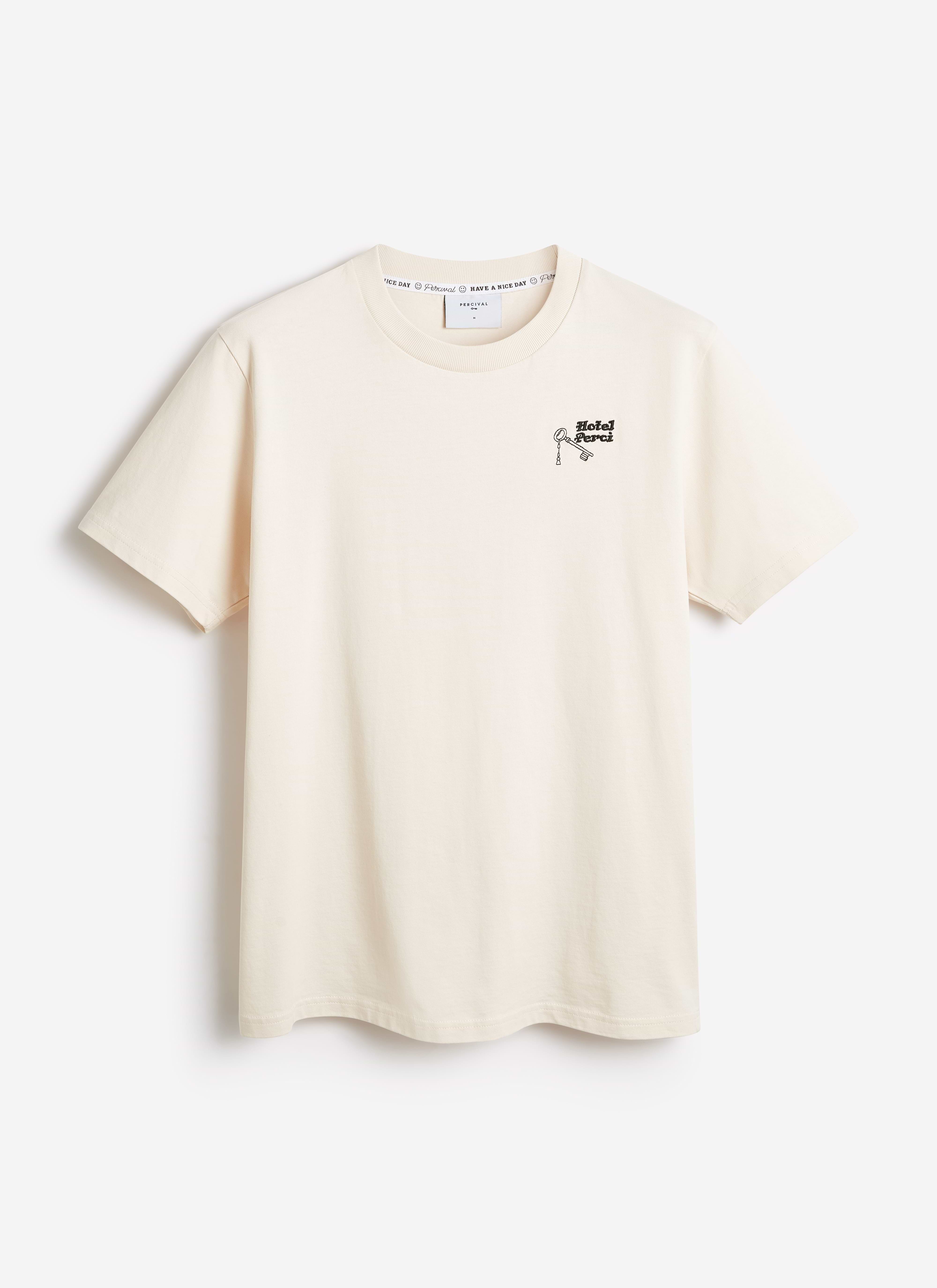 Percival Hotel T-shirt in ecru organic cotton, featuring a small 'Hotel Perci' key graphic on the chest.