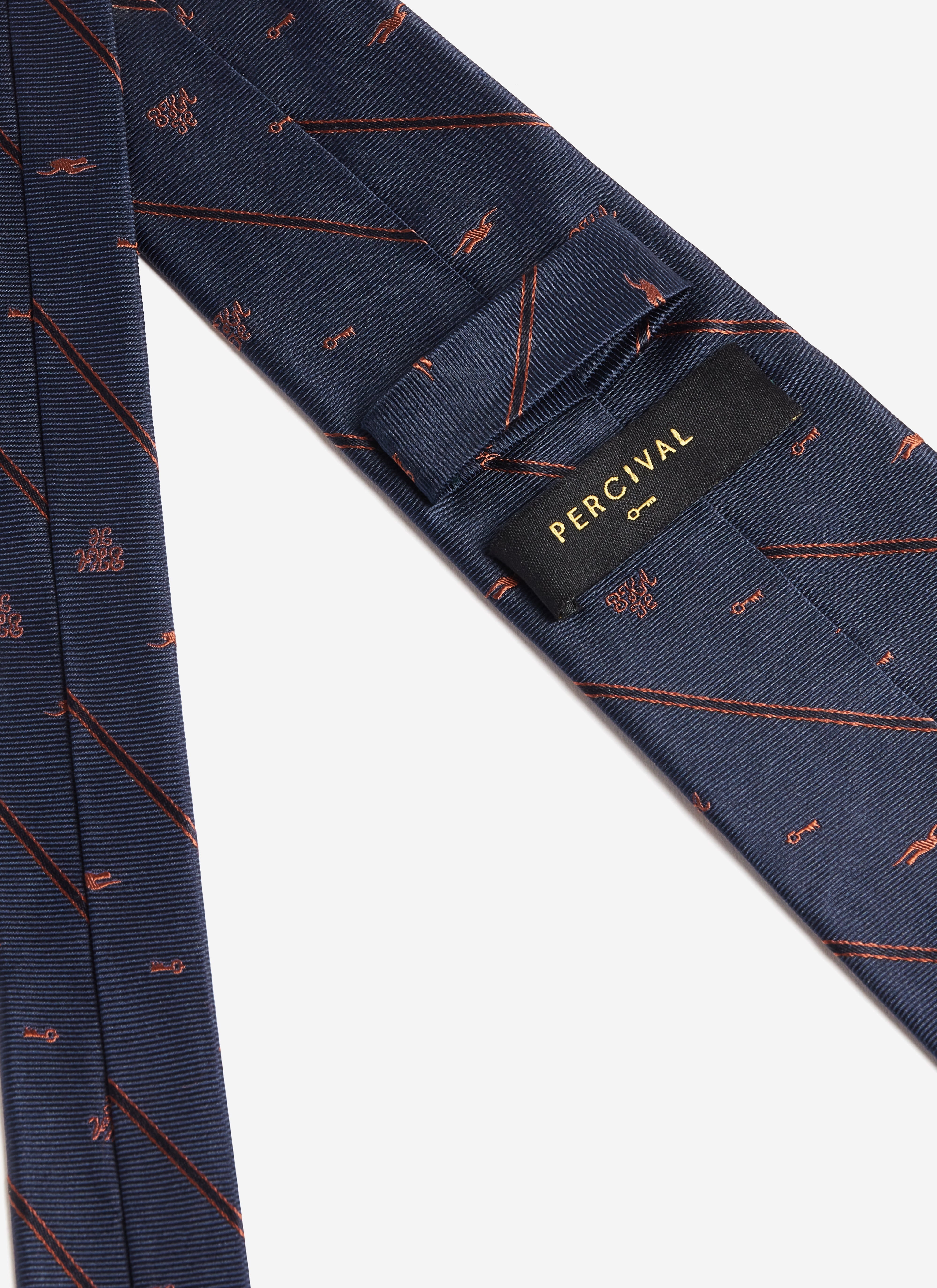 A close-up of the Percival label on the reverse of the navy Brighton & Hove Albion F.C. x Percival Jacquard Stripe Silk Tie.