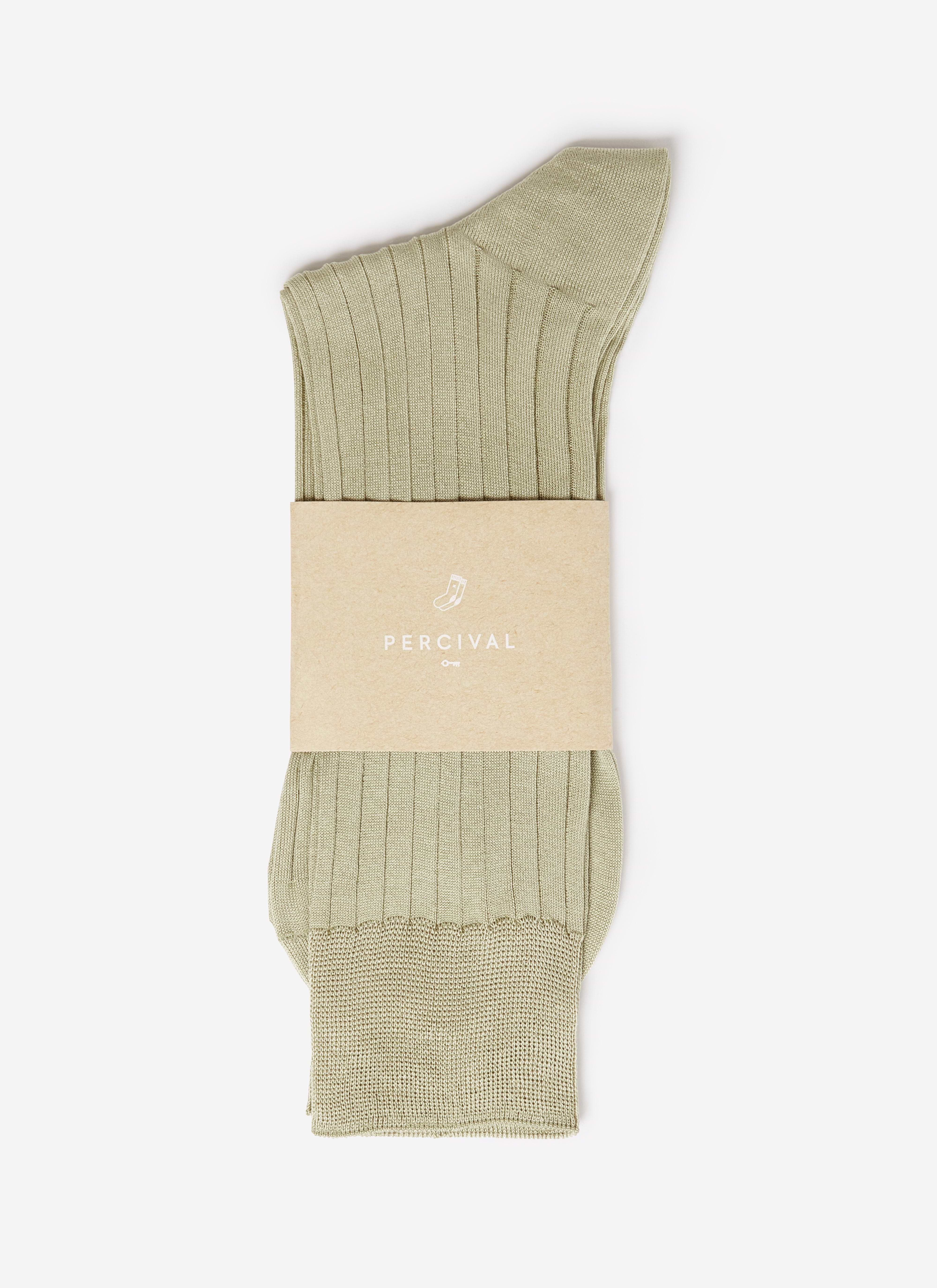 A pair of sage green ribbed cotton Percival Loafer Dress Socks, shown folded with branded paper packaging.