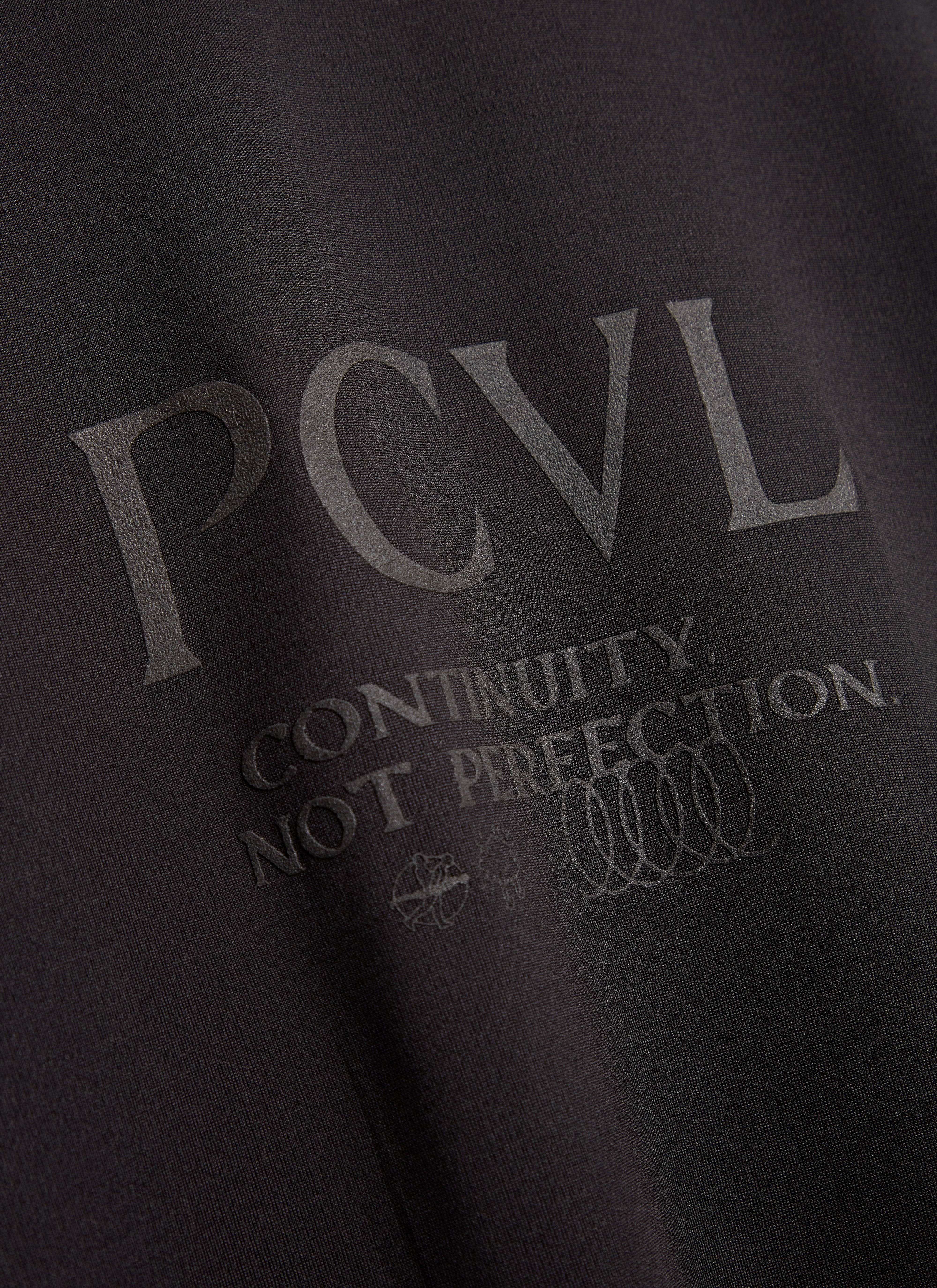 A close-up of the back of the black PCVL Long Sleeve Performance Top by Percival, showing the ventilated mesh panel.