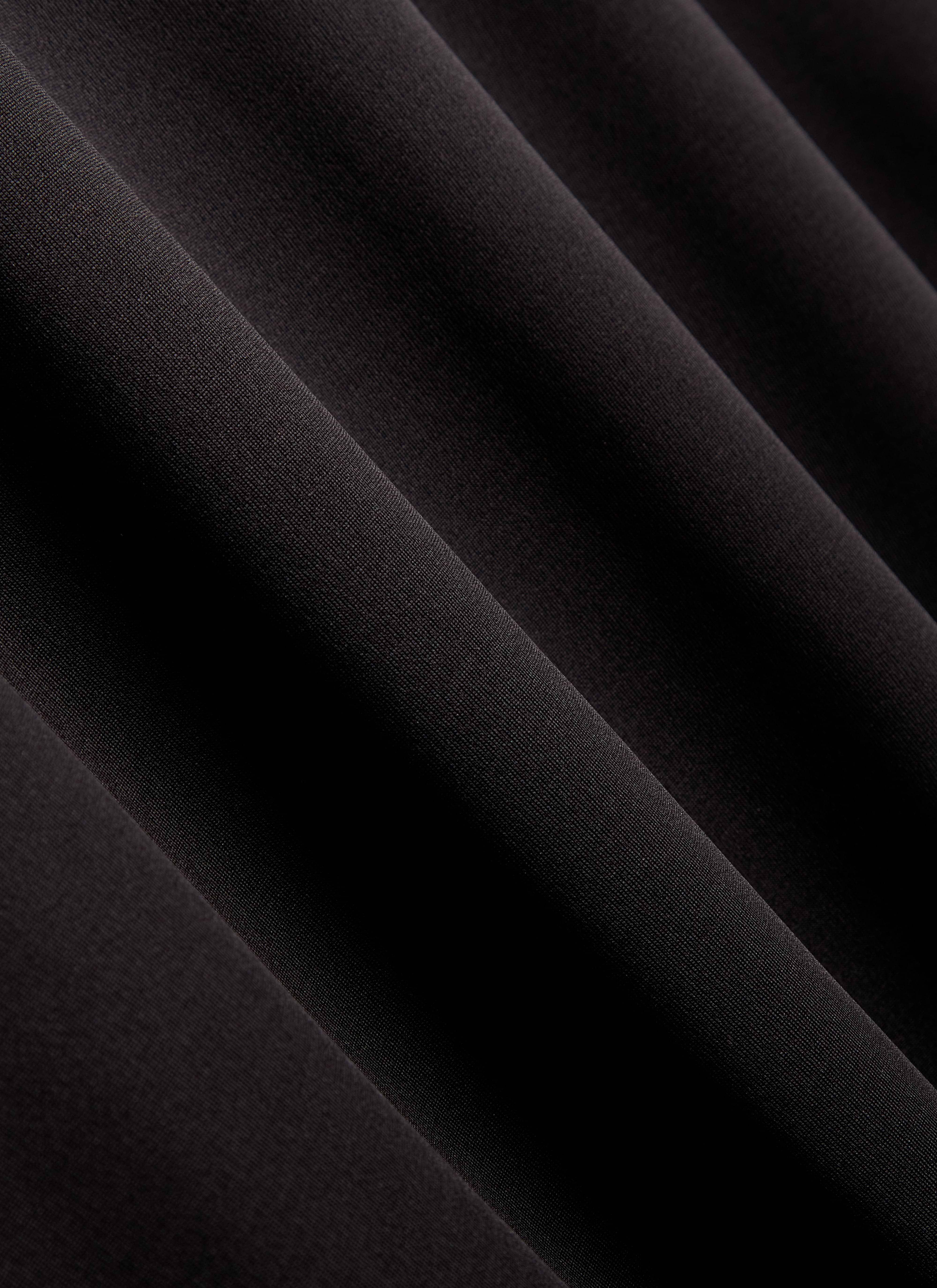 A detailed close-up of the technical, moisture-wicking fabric of the black PCVL Performance Top by Percival.