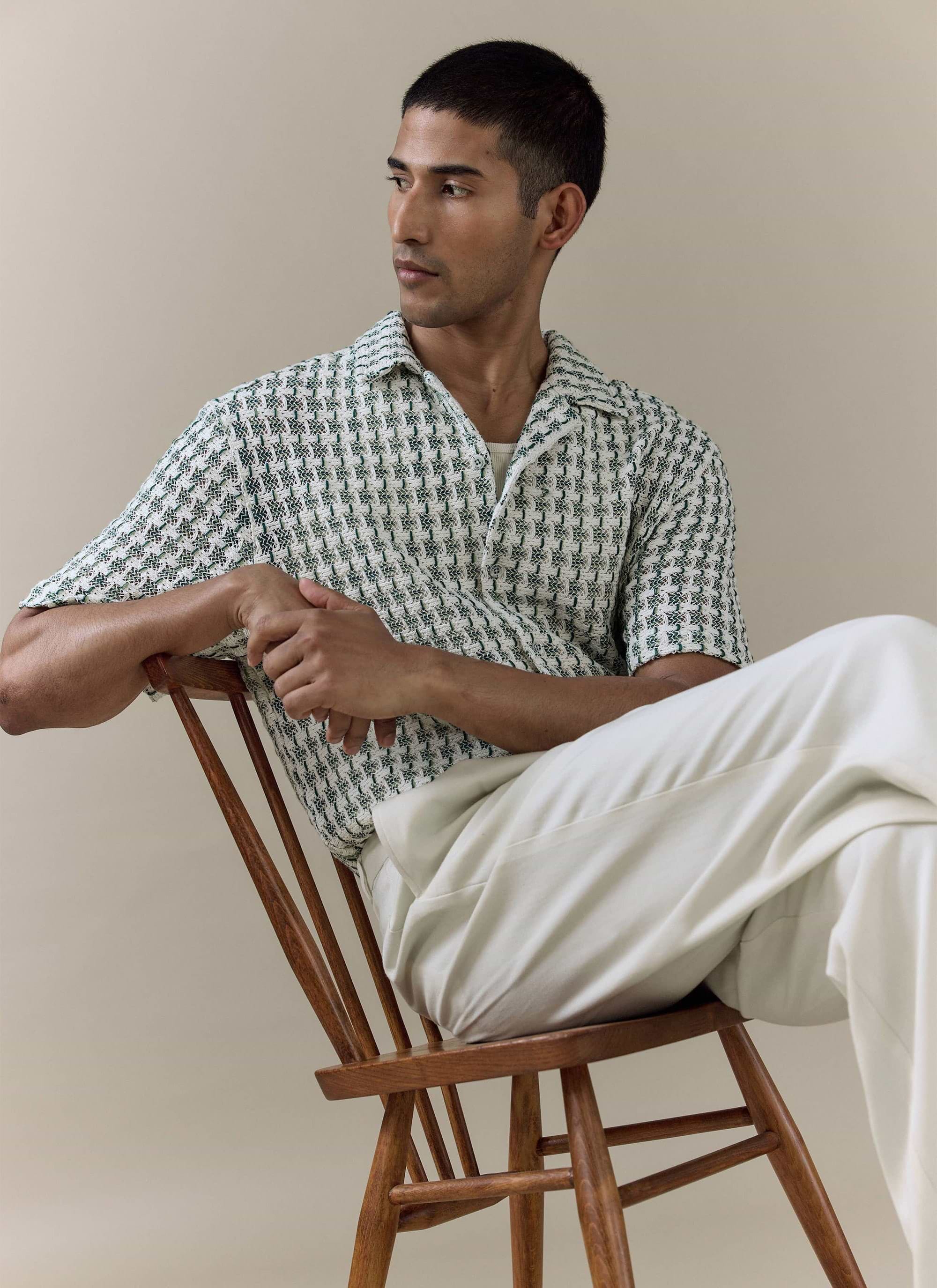 Percival Freddie Crochet Boxy Shirt in green cotton knit, worn by a model sitting on a wooden chair.