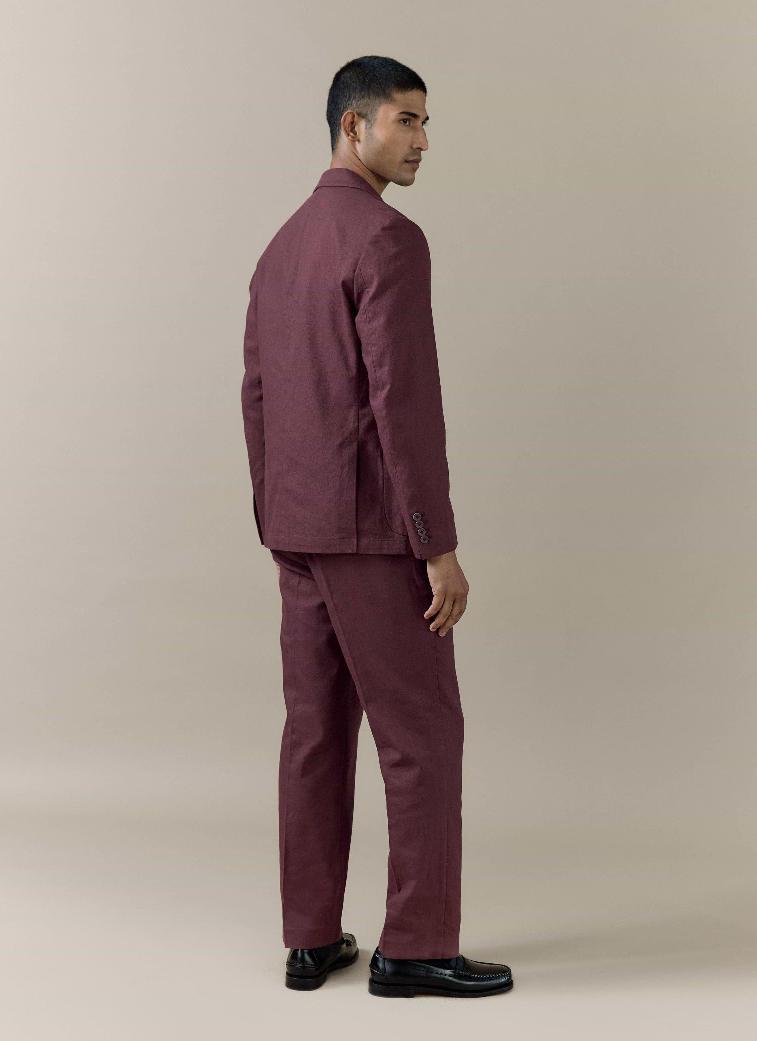 Tailored linen blazer and matching trousers in merlot by Percival, shown from a rear side-profile on a model.
