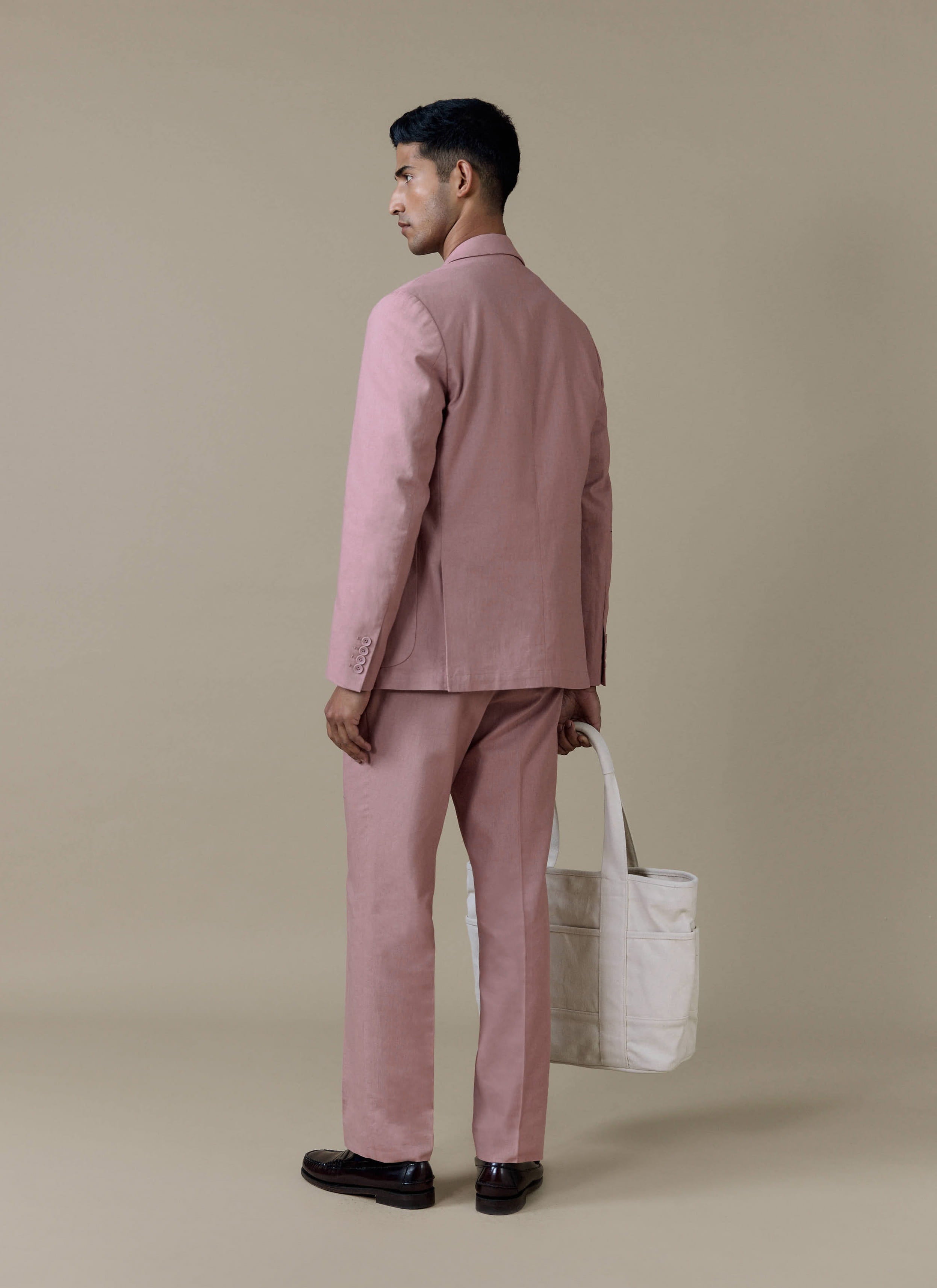 Percival dusty pink tailored linen suit and cream canvas tote bag, shown from behind on a model.