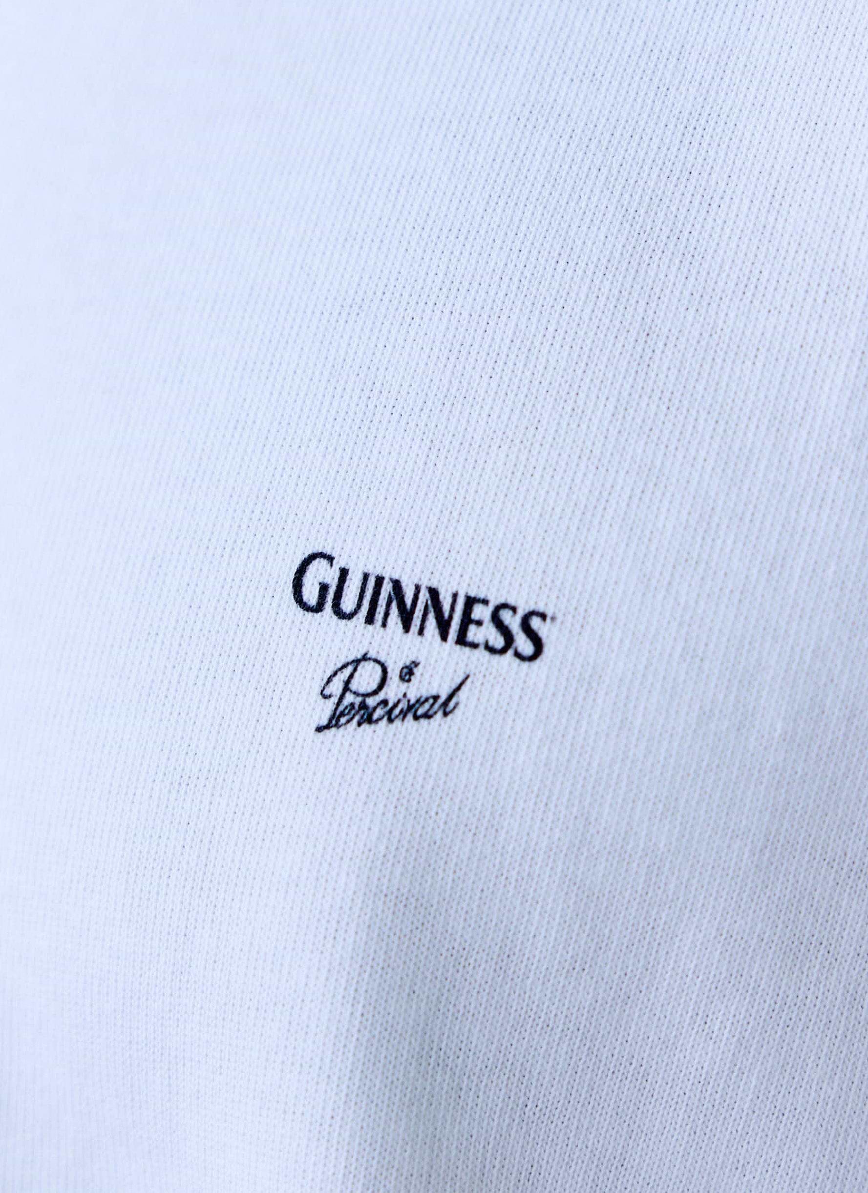 A close-up of the black Guinness and Percival logo on the chest of the white Guinness x Percival Oversized T-Shirt.