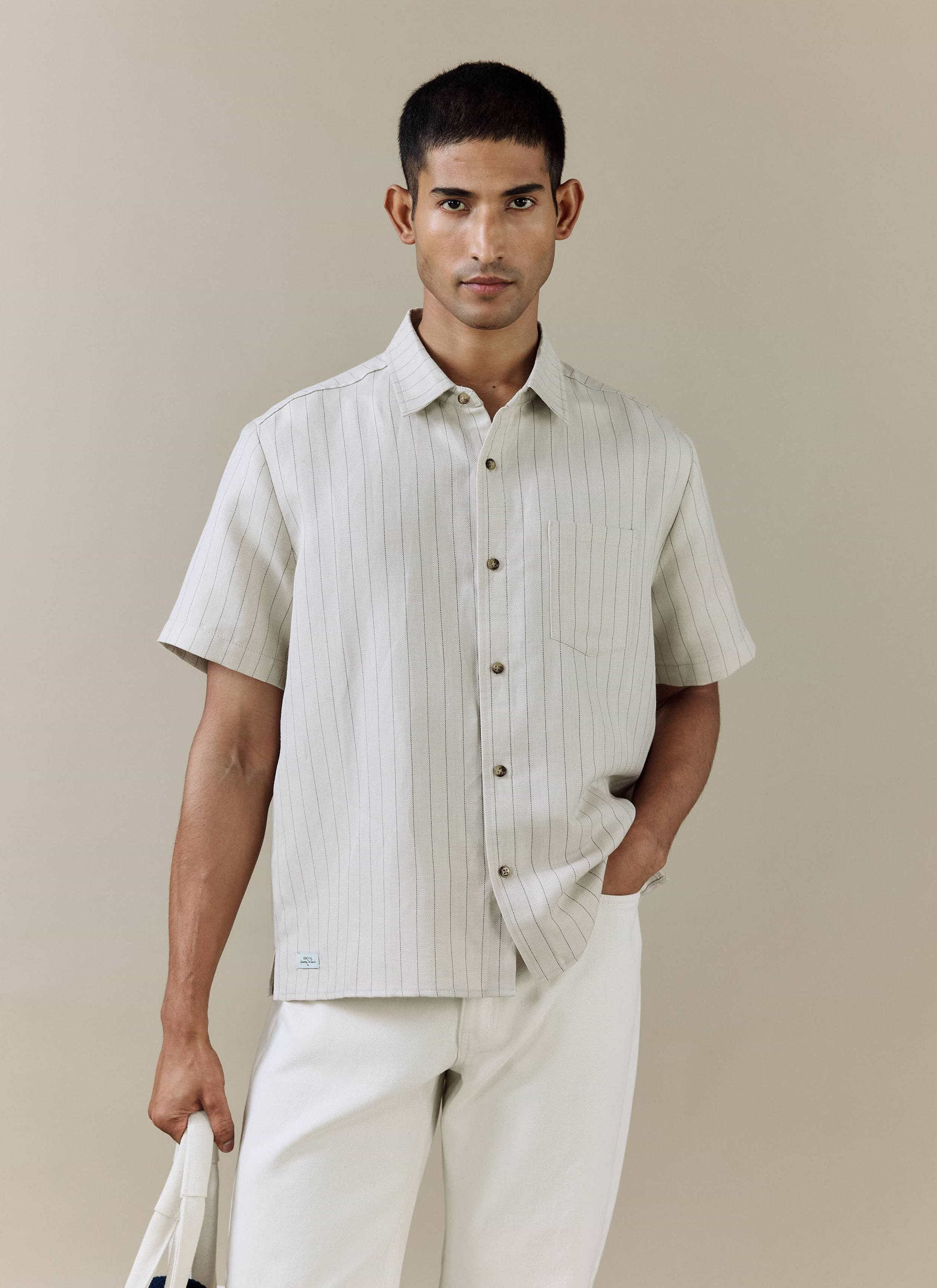 Model wears the Percival Striped Boxy Shirt in cream linen blend, featuring subtle pinstripes and a herringbone weave.
