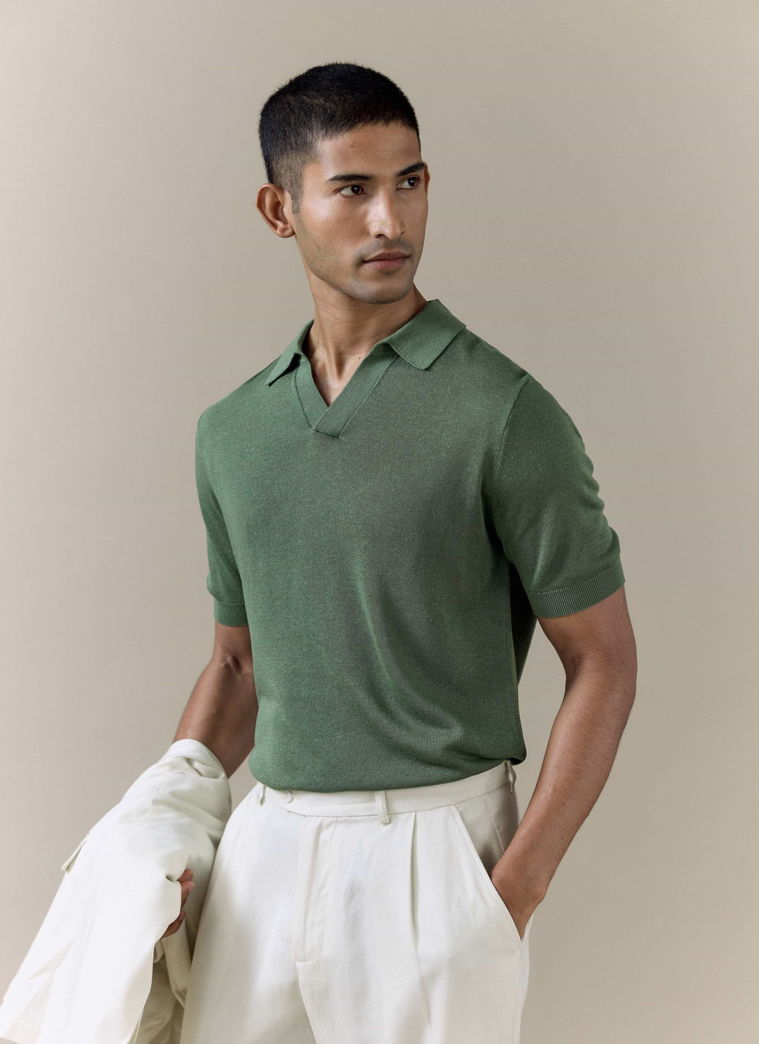 Model wearing the forest green Percival Laurence Knitted Polo in a linen lyocell blend with an open V collar.