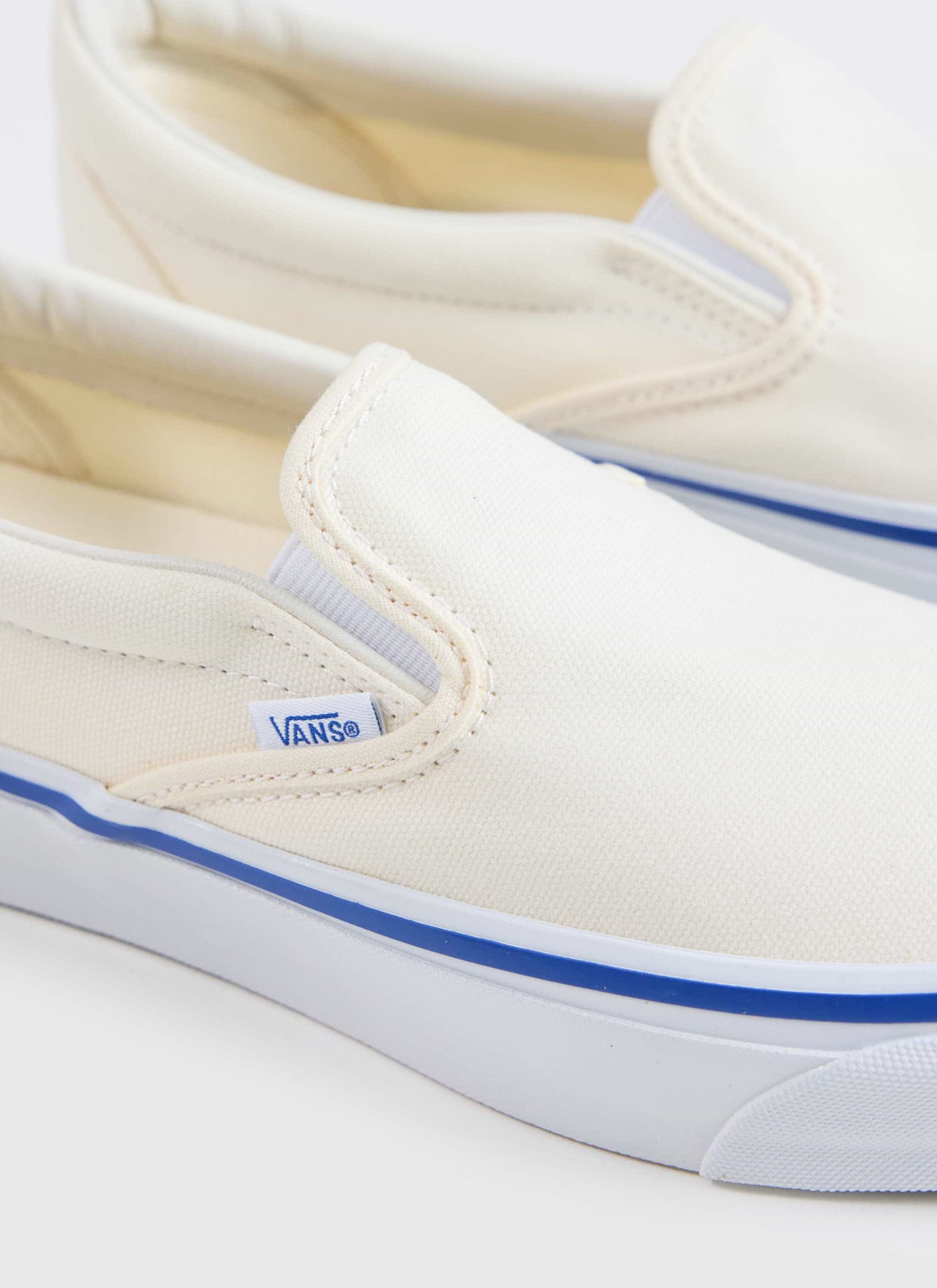 A close-up of the Vans Slip-On Reissue 98 in off white canvas with a blue foxing stripe, available at Percival.
