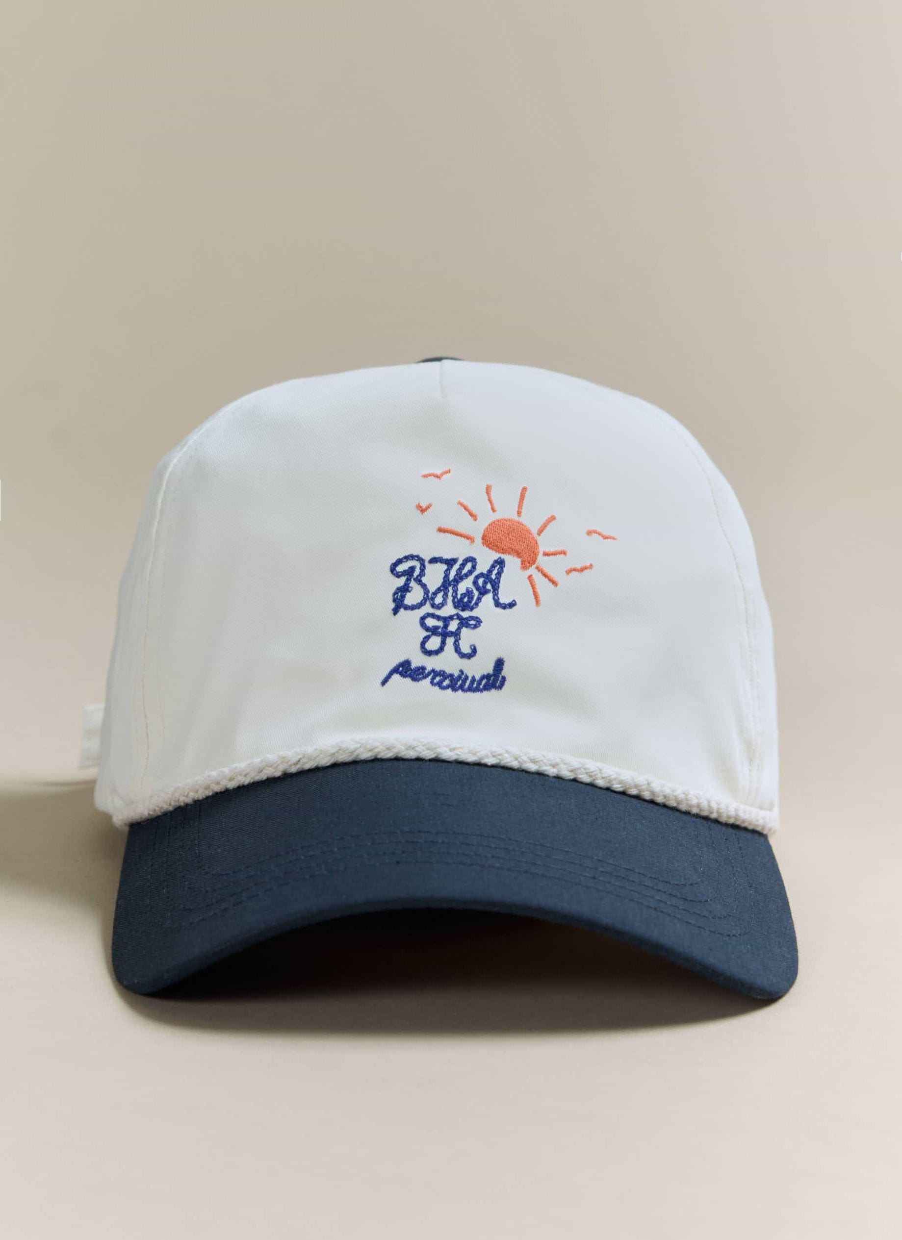 A close-up of the Percival x Brighton & Hove Albion F.C. trucker cap, showing the embroidered logo on the cream front panel.