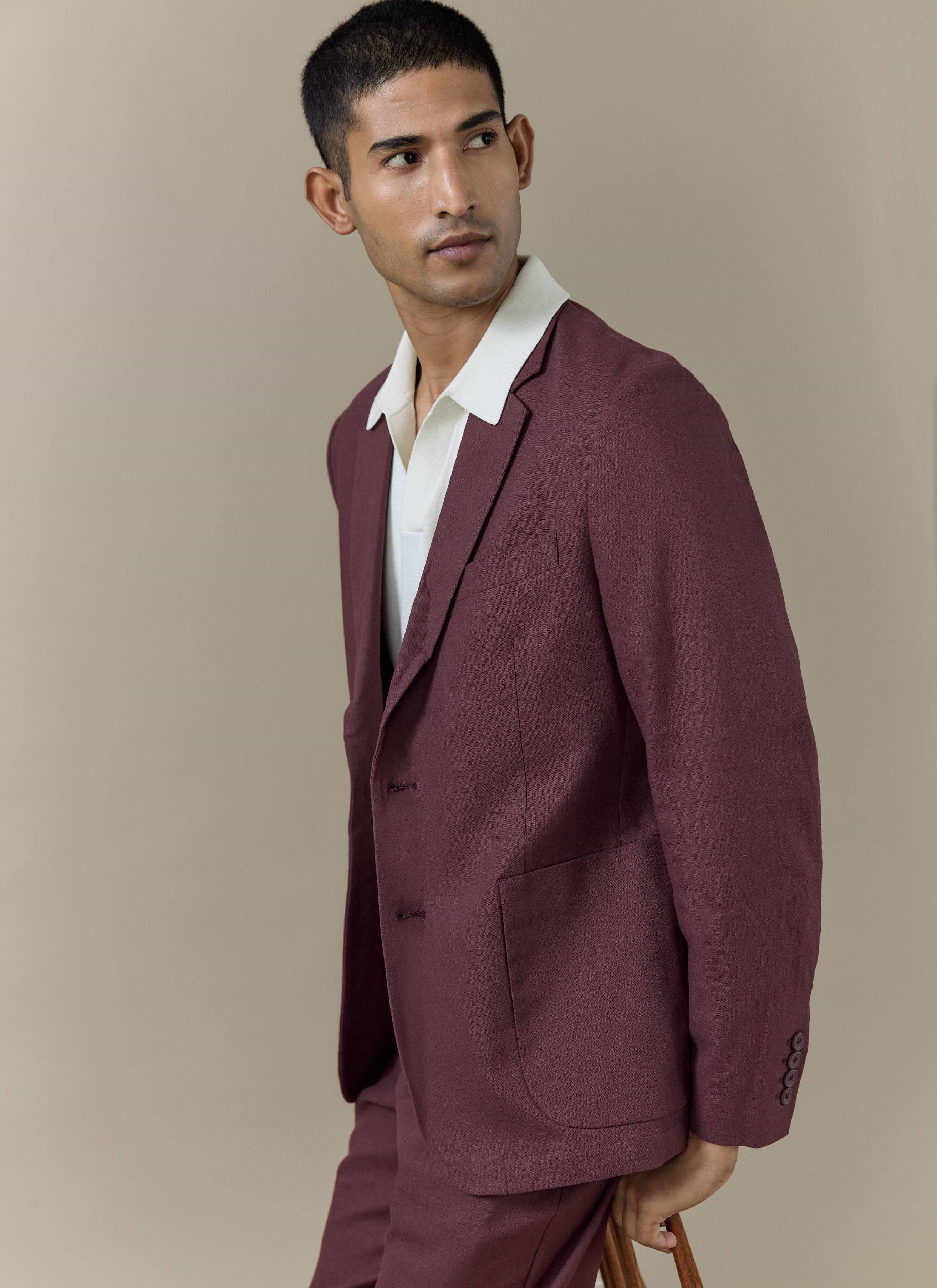 Cream Laurence Knitted Polo by Percival with a Johnny collar, layered under a tailored burgundy linen suit jacket.