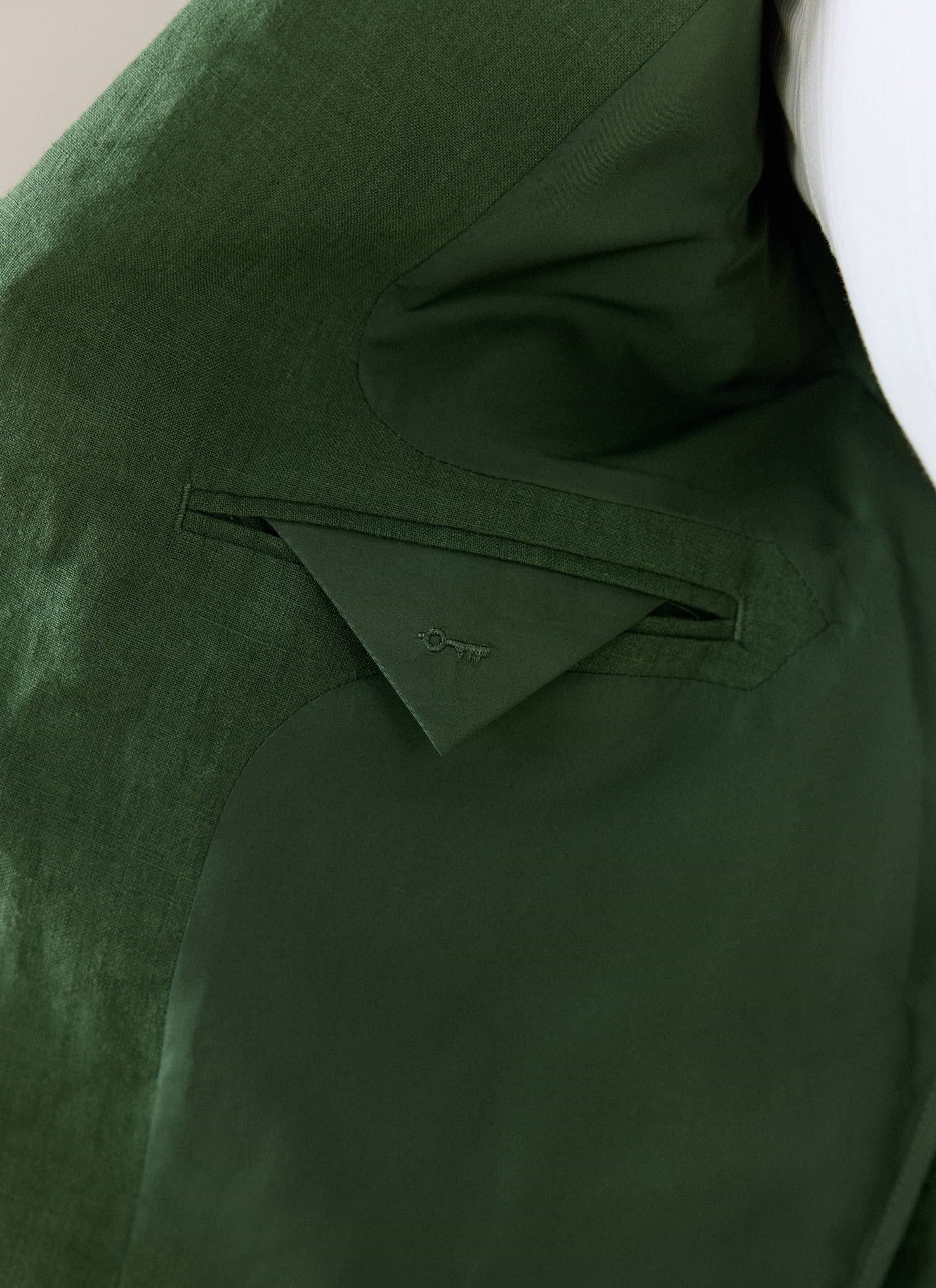 Internal pocket and lining detail of the Percival forest green linen blazer, featuring a tonal embroidered key logo.
