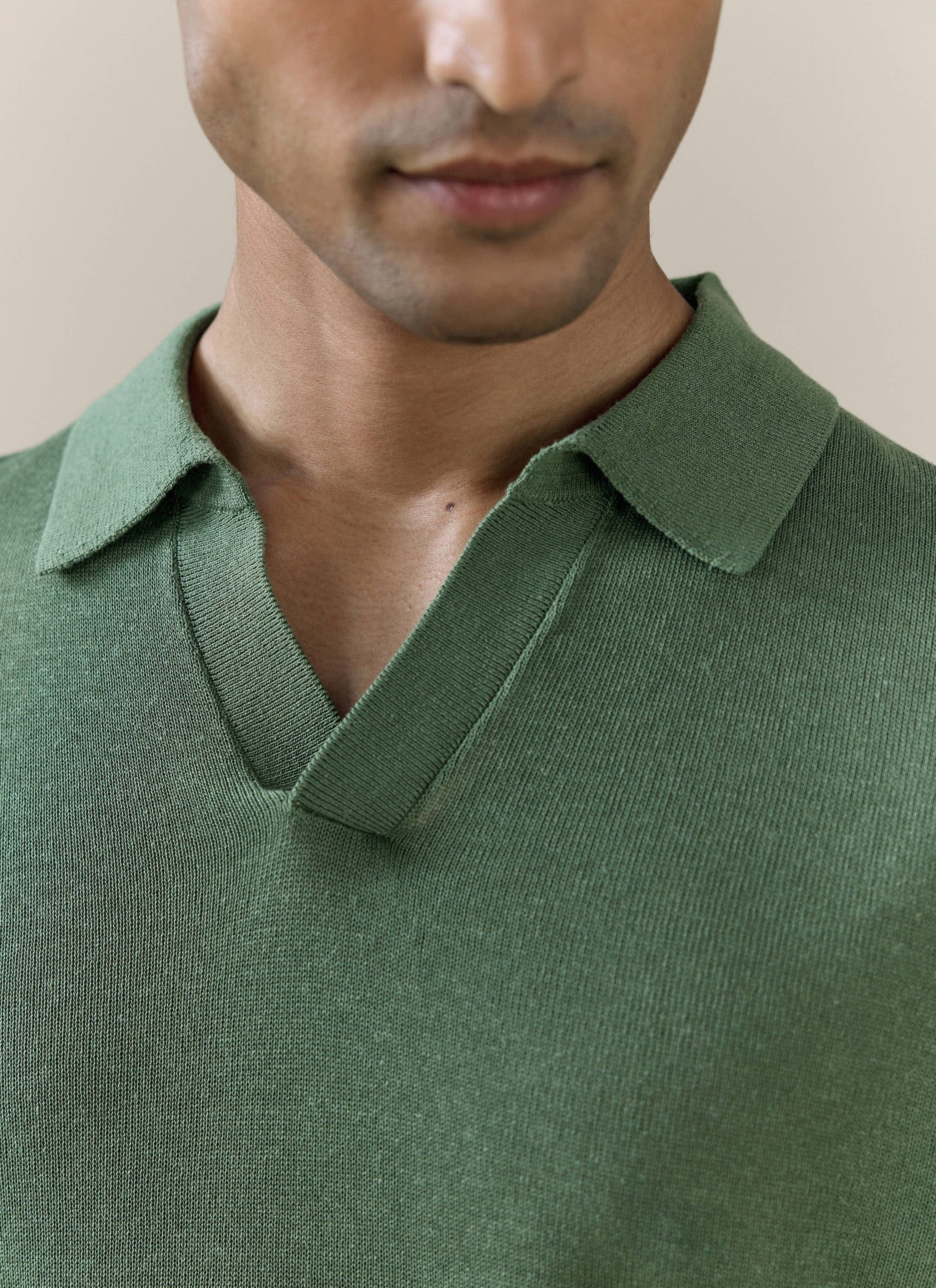Close-up of the forest green Percival Laurence Knitted Polo, featuring the open V placket and fine-gauge knit texture.