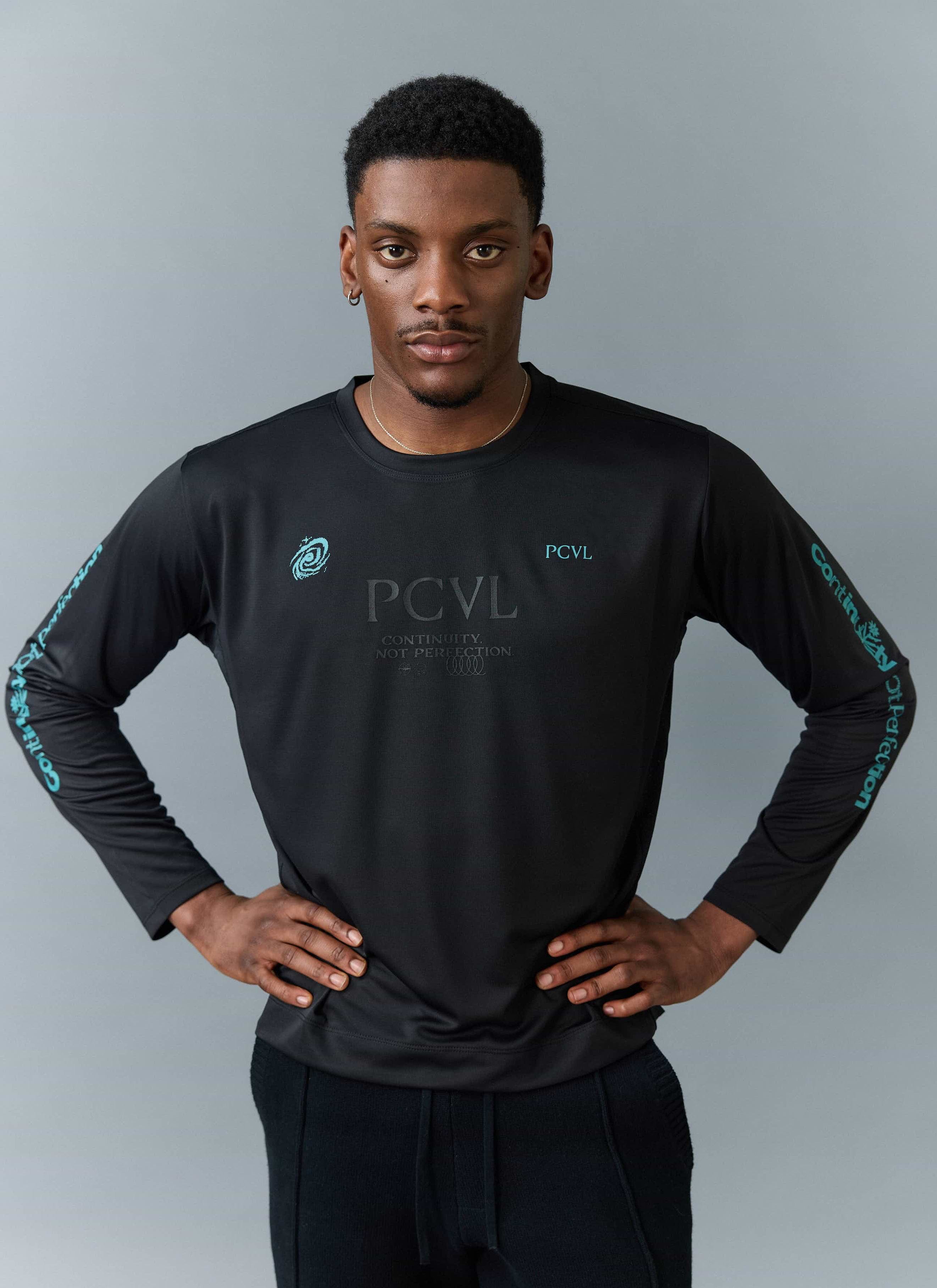 A model wears the Percival PCVL Long Sleeve Printed Performance Top in black, showing the chest and sleeve graphics.