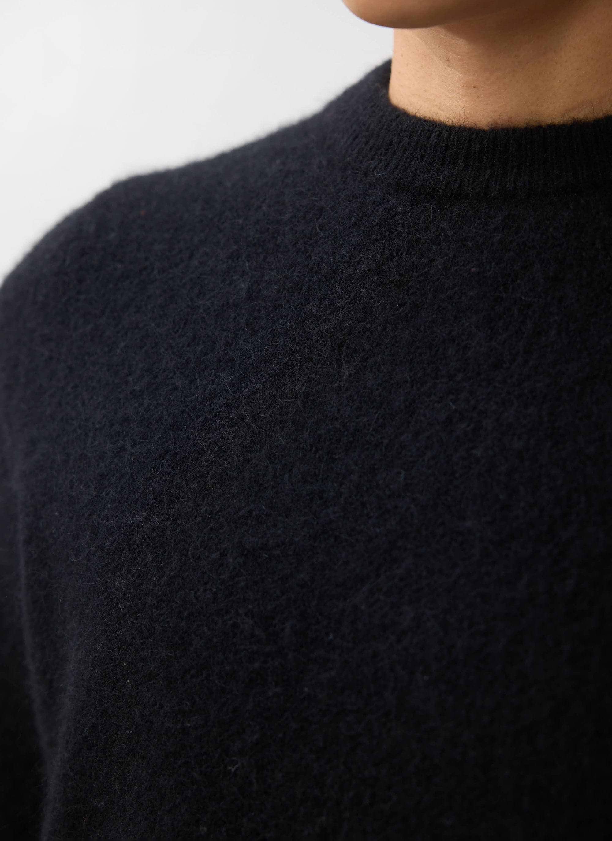 Close up of the Percival White Glove Crew Neck Jumper in black mohair, showing the soft texture and neckline.