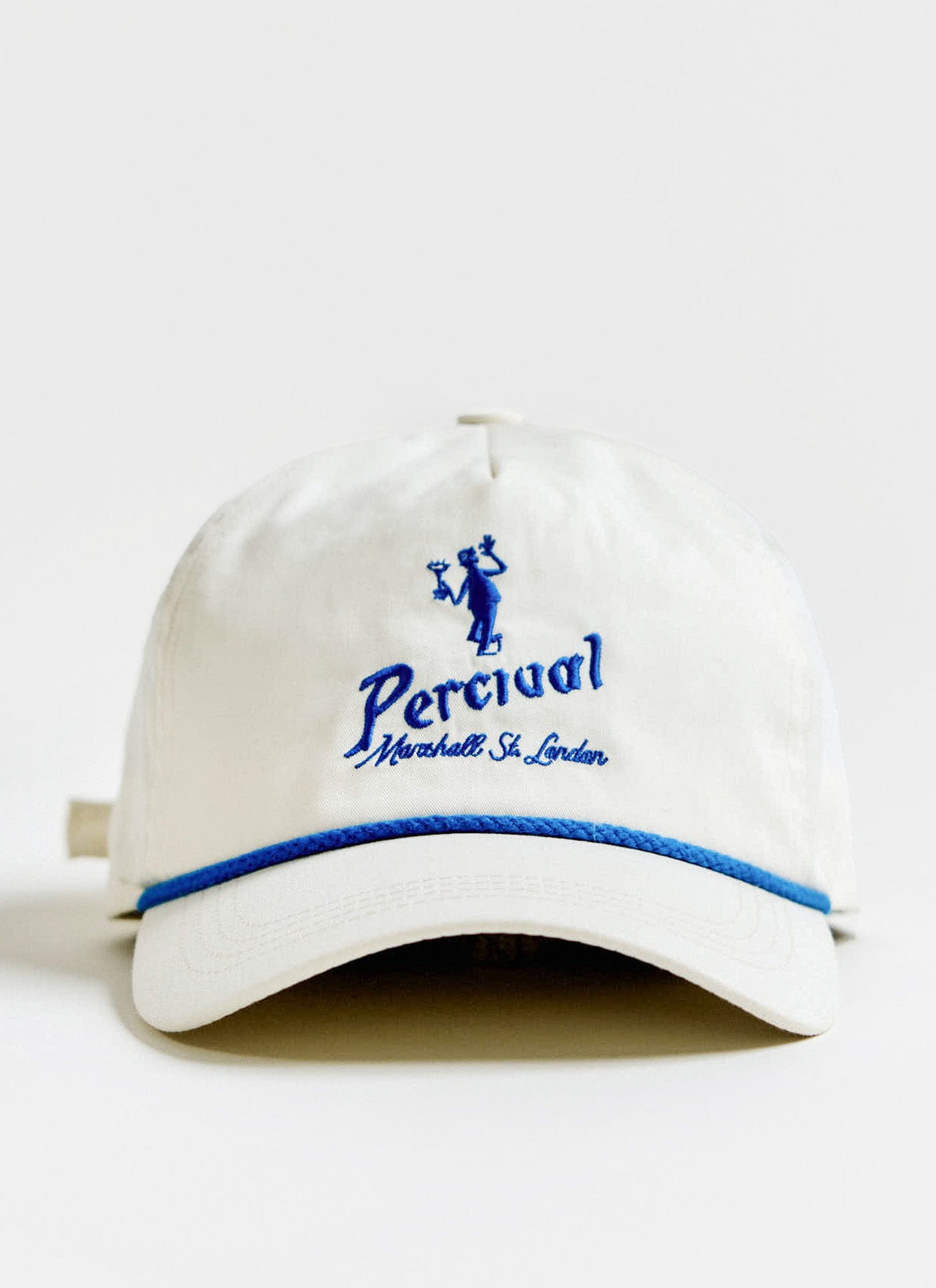 Front view of the cream Percival Martini Soft Trucker Cap, showing the blue embroidery and contrast rope detail.