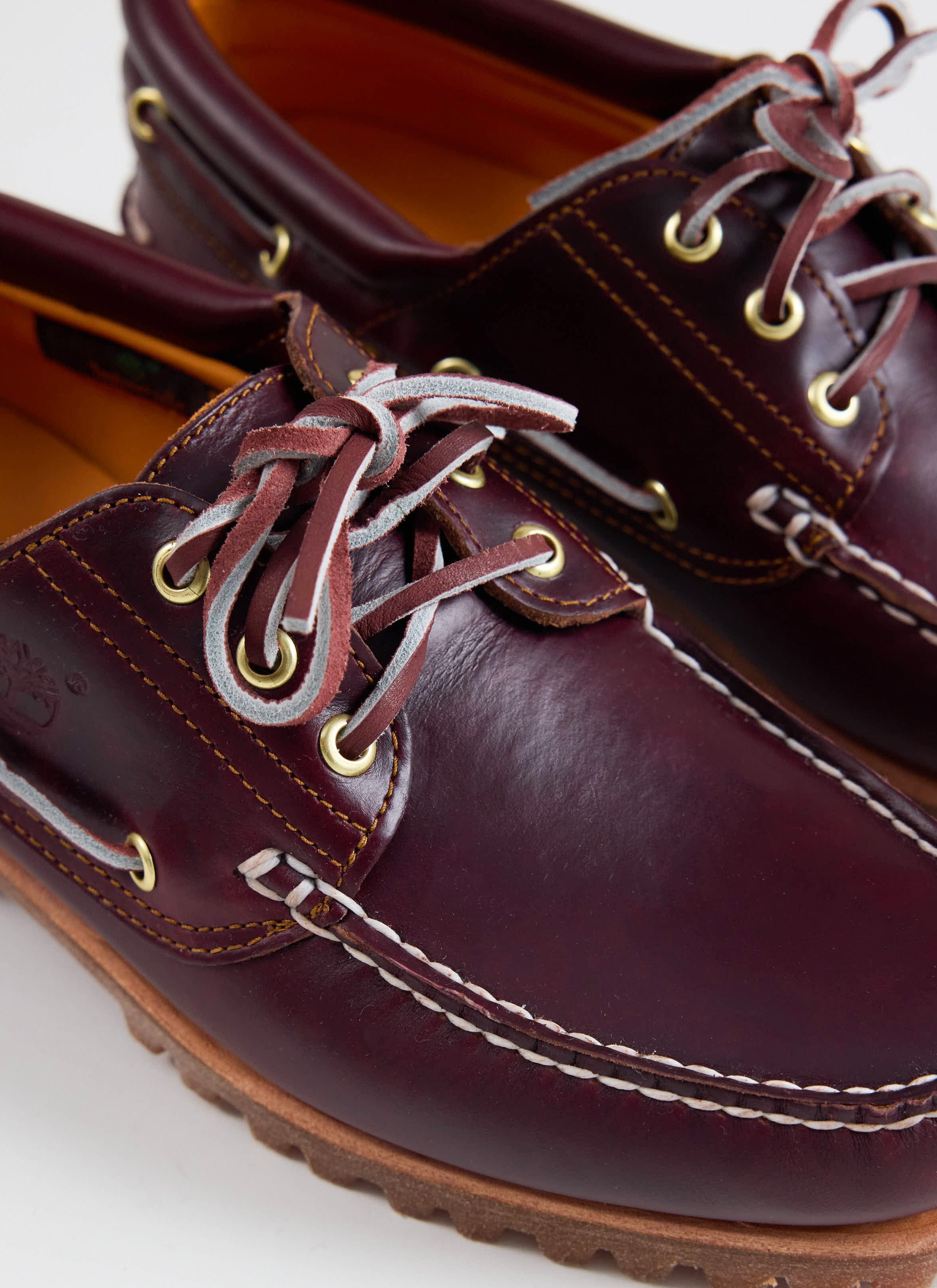 Close-up of the burgundy leather Timberland Authentic Boat Shoe at Percival, showing the handsewn rawhide lacing.