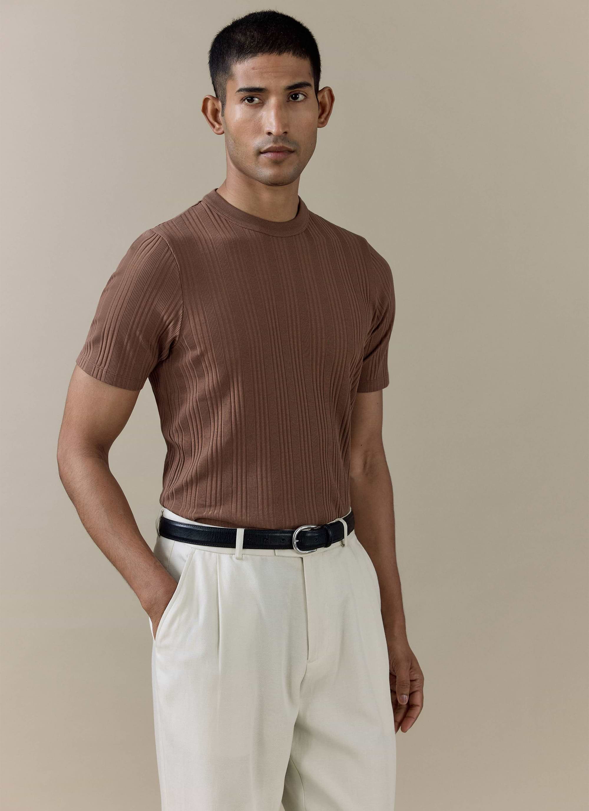 Percival Leon ribbed t-shirt in brown organic cotton, worn by a model with cream trousers.