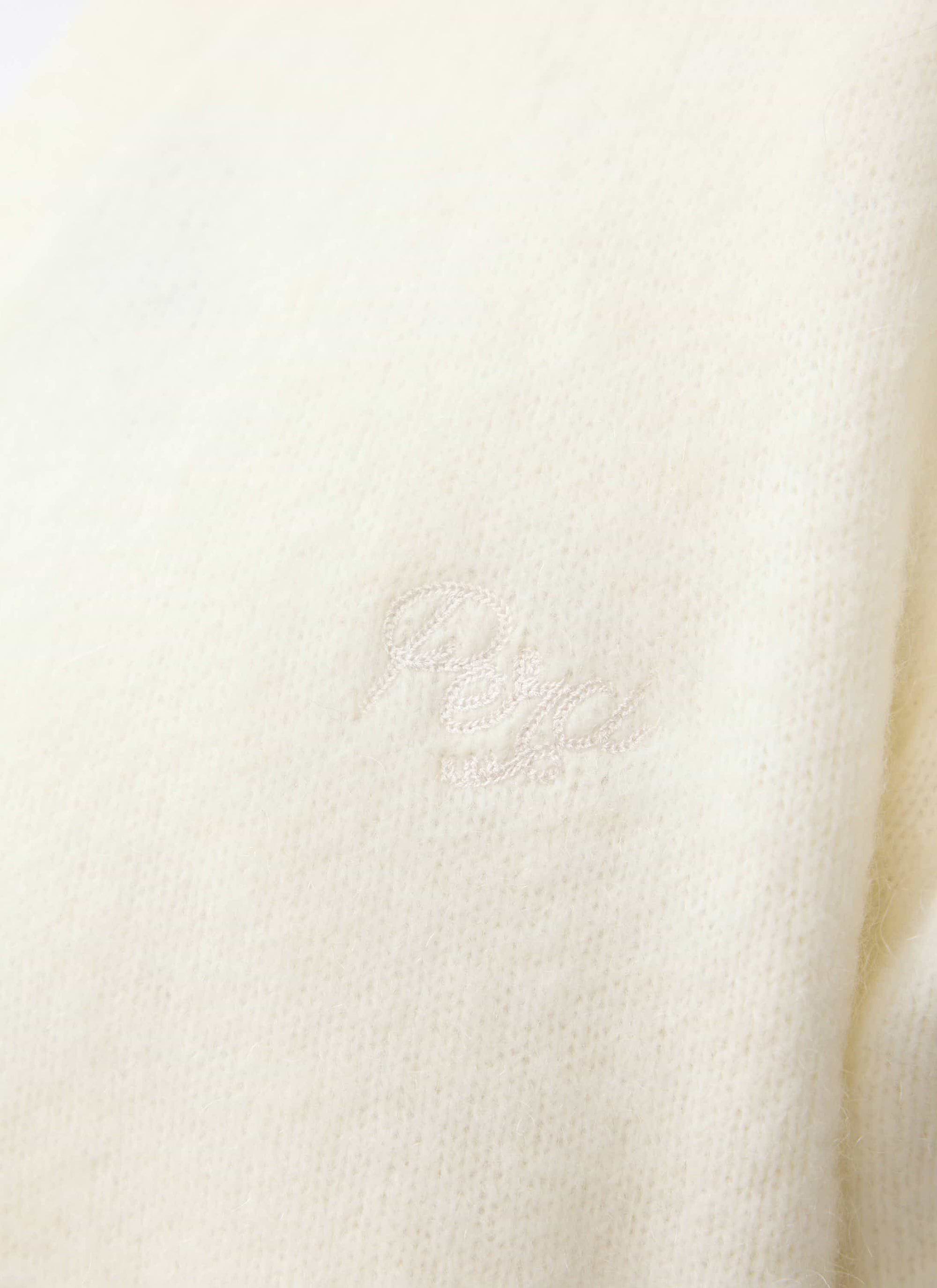 A close-up of the tonal embroidery on the chest of the ecru White Glove Mohair Cardigan by Percival.
