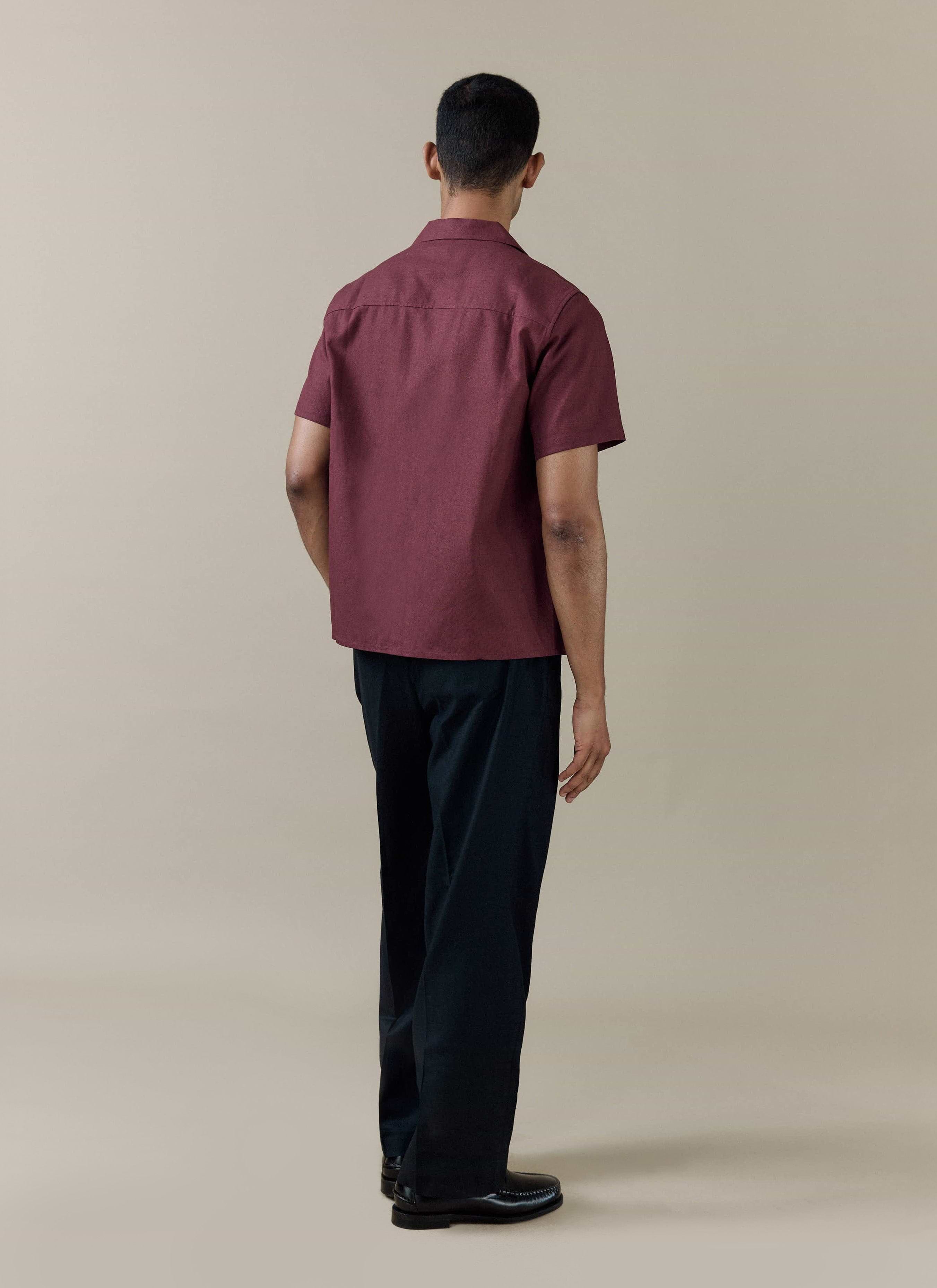 Rear view of the Percival Short Sleeve Cuban Shirt in Merlot linen-cotton blend, styled with black trousers.