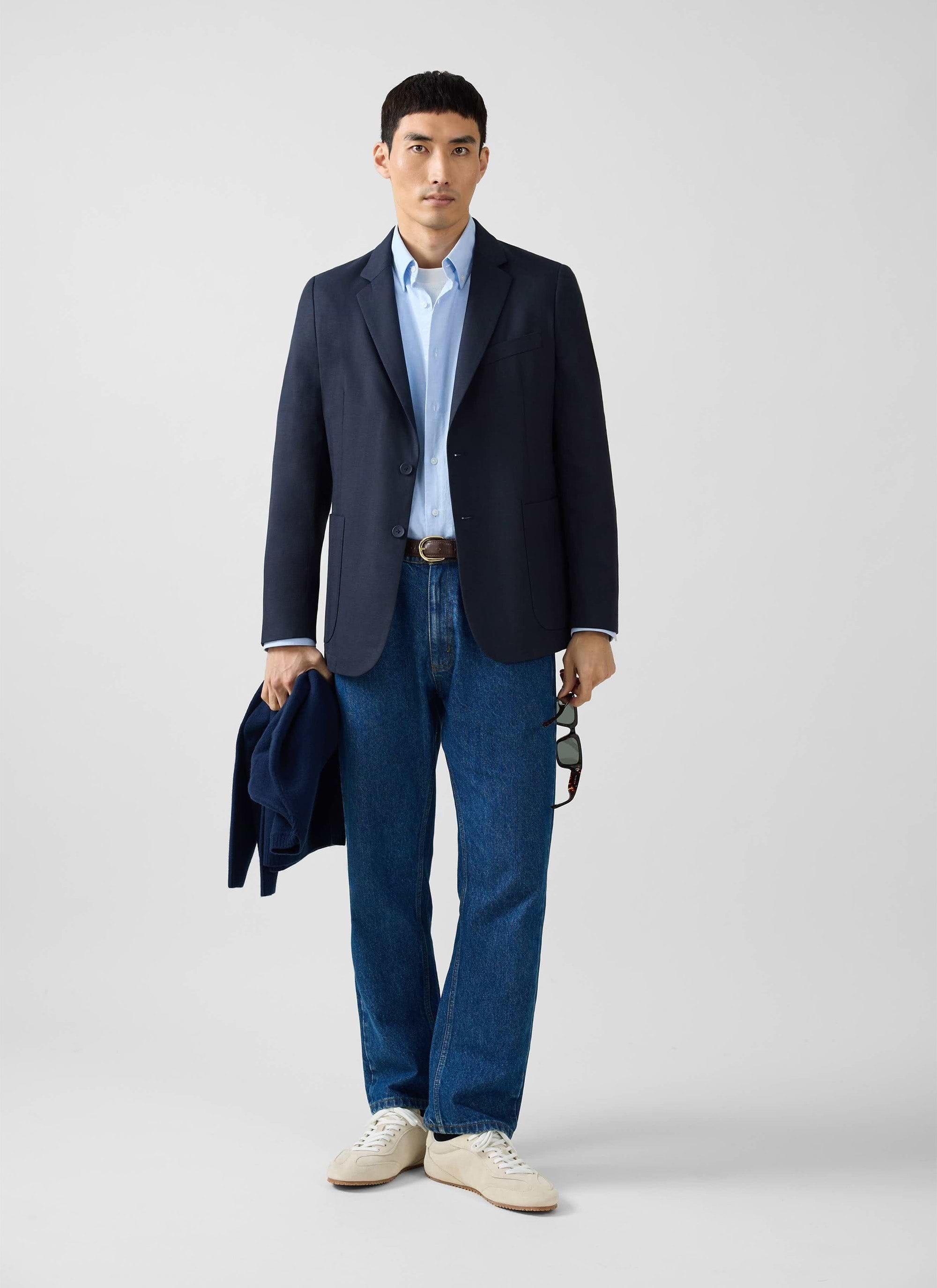 A model wears the Percival navy Lyocell Regular Blazer, paired with a light blue shirt and dark blue jeans.