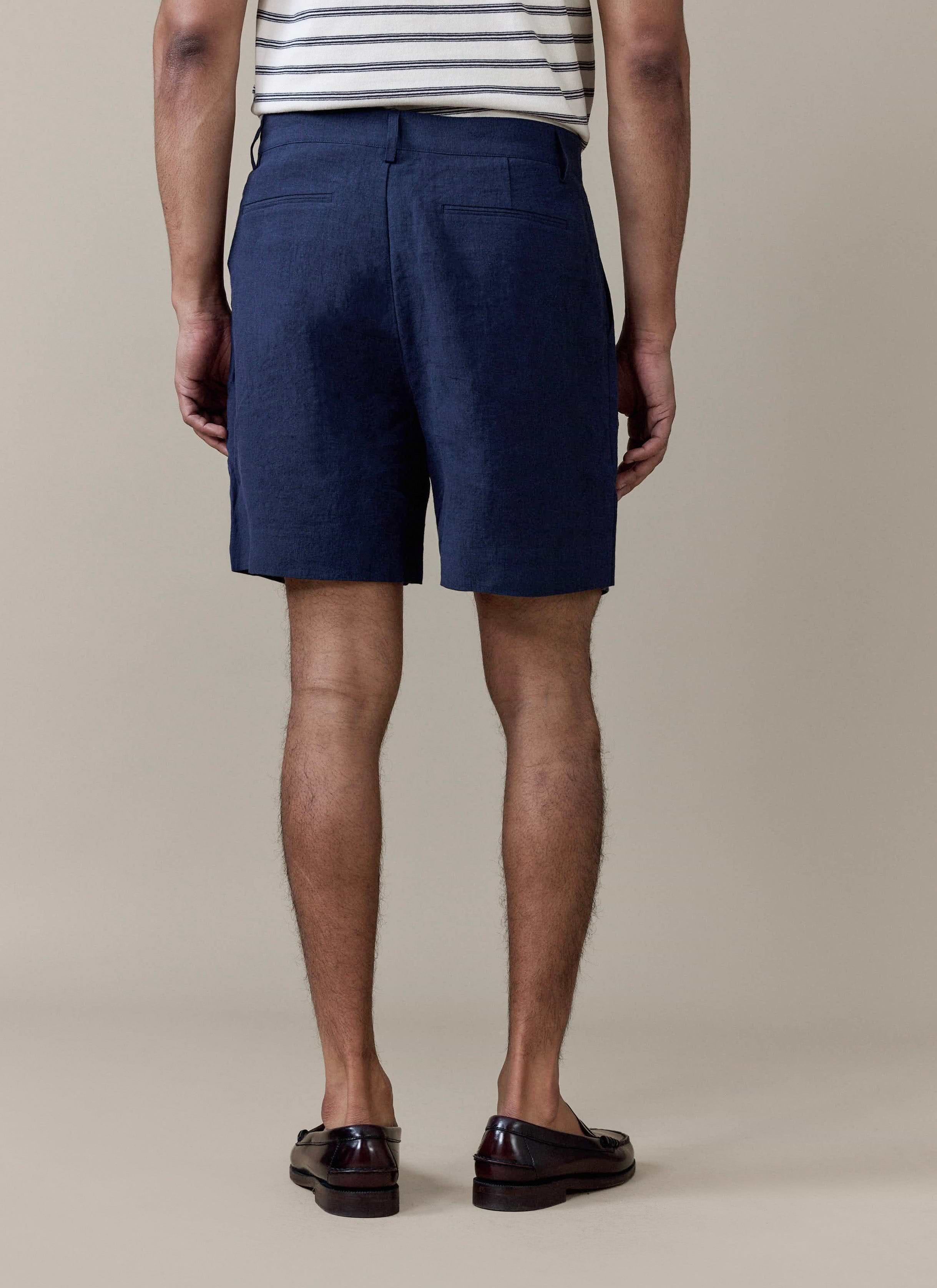 Rear view of the Percival pleated linen shorts in navy, highlighting the tailored fit and back welt pockets.