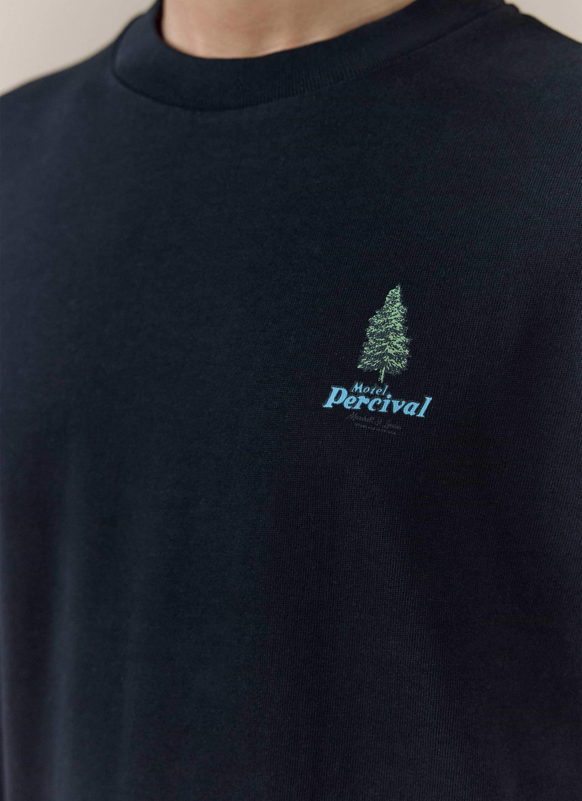 Close-up of the black Percival Arnold Oversized T Shirt, featuring a green tree and blue Motel Percival chest graphic.