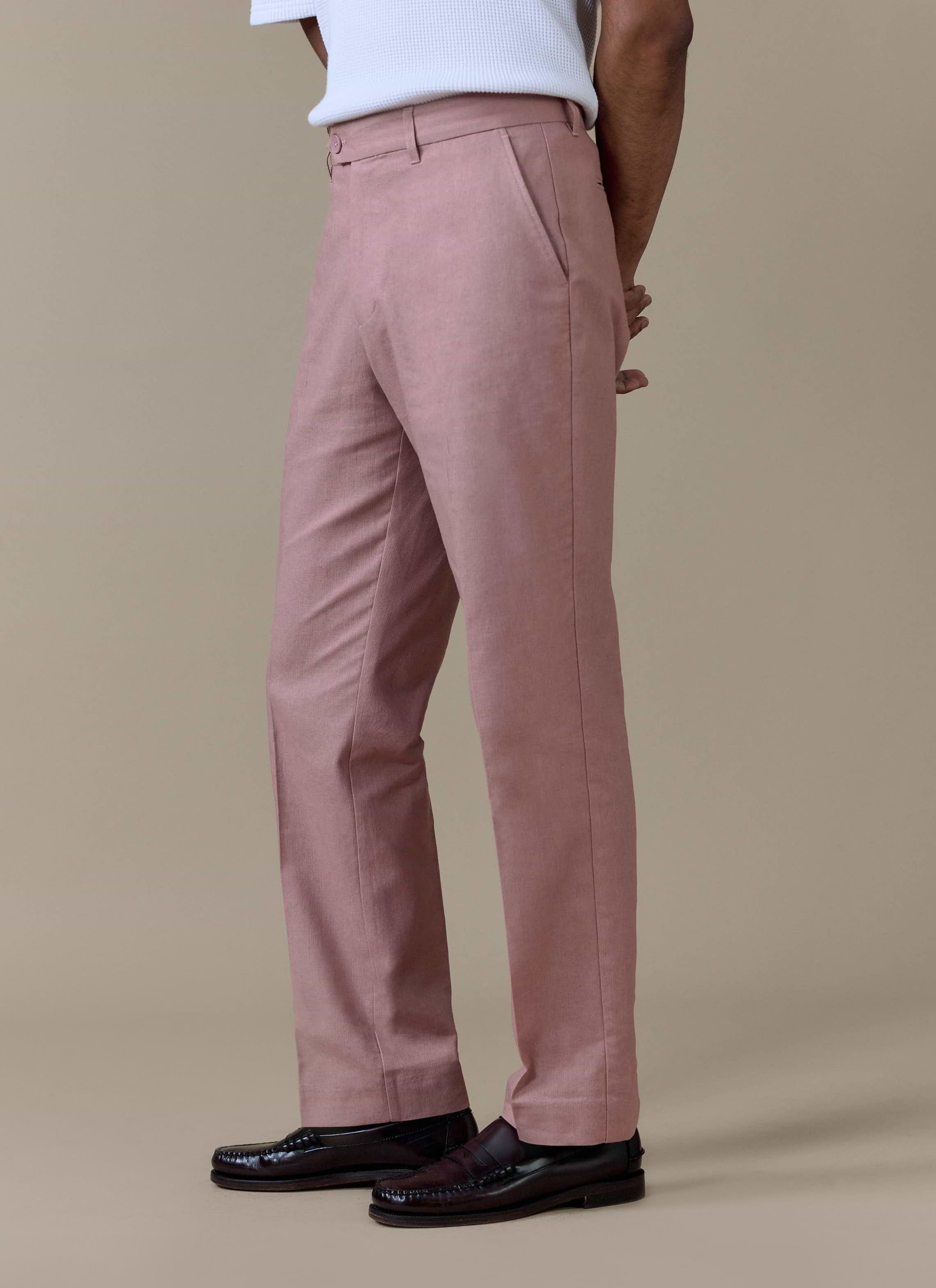 Percival tailored linen trousers in dusty pink with a straight leg and sharp centre crease, styled with loafers.