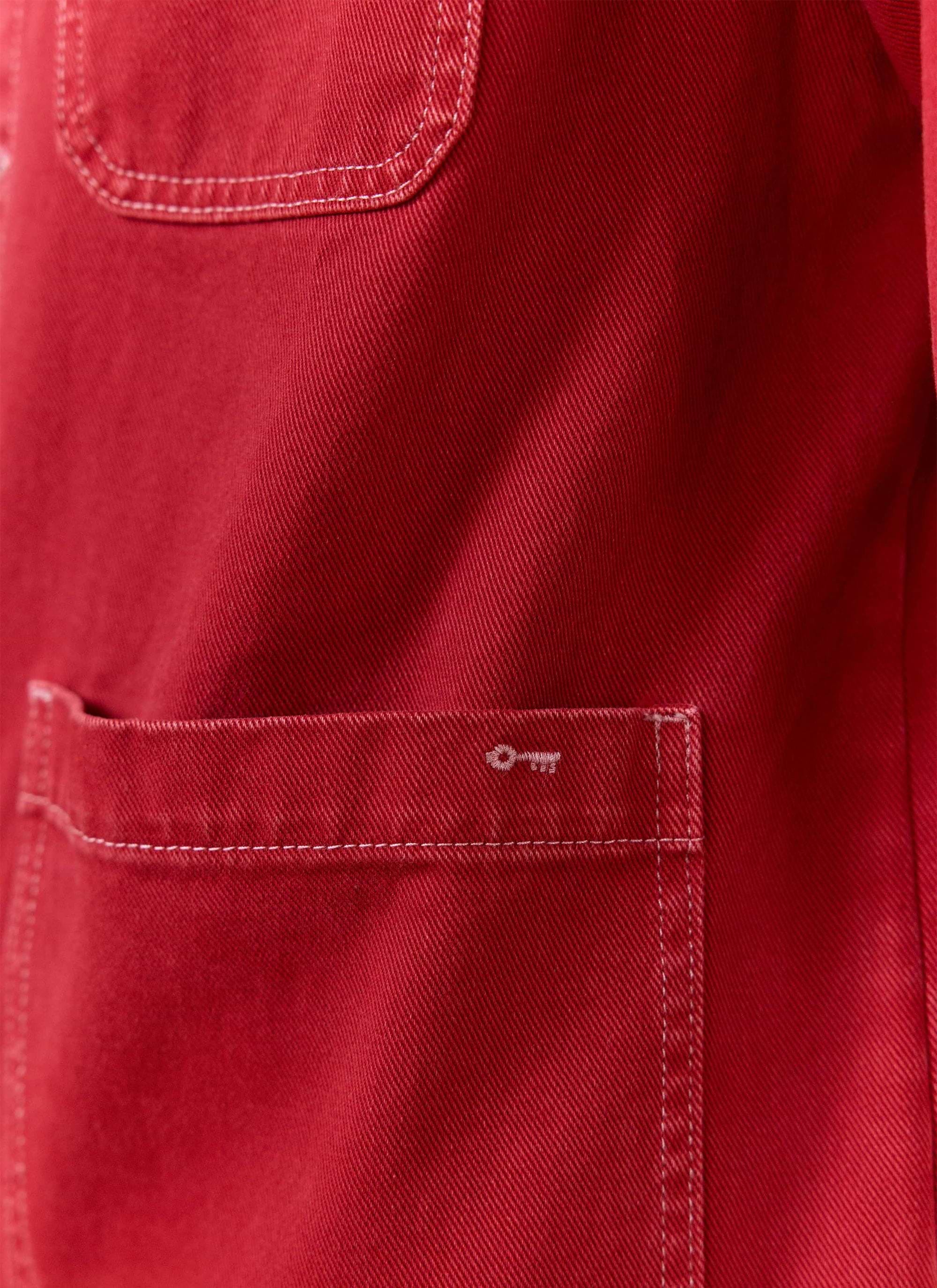 Detail of the red cotton canvas pocket with white key embroidery on the Percival Oliver Chore Jacket.