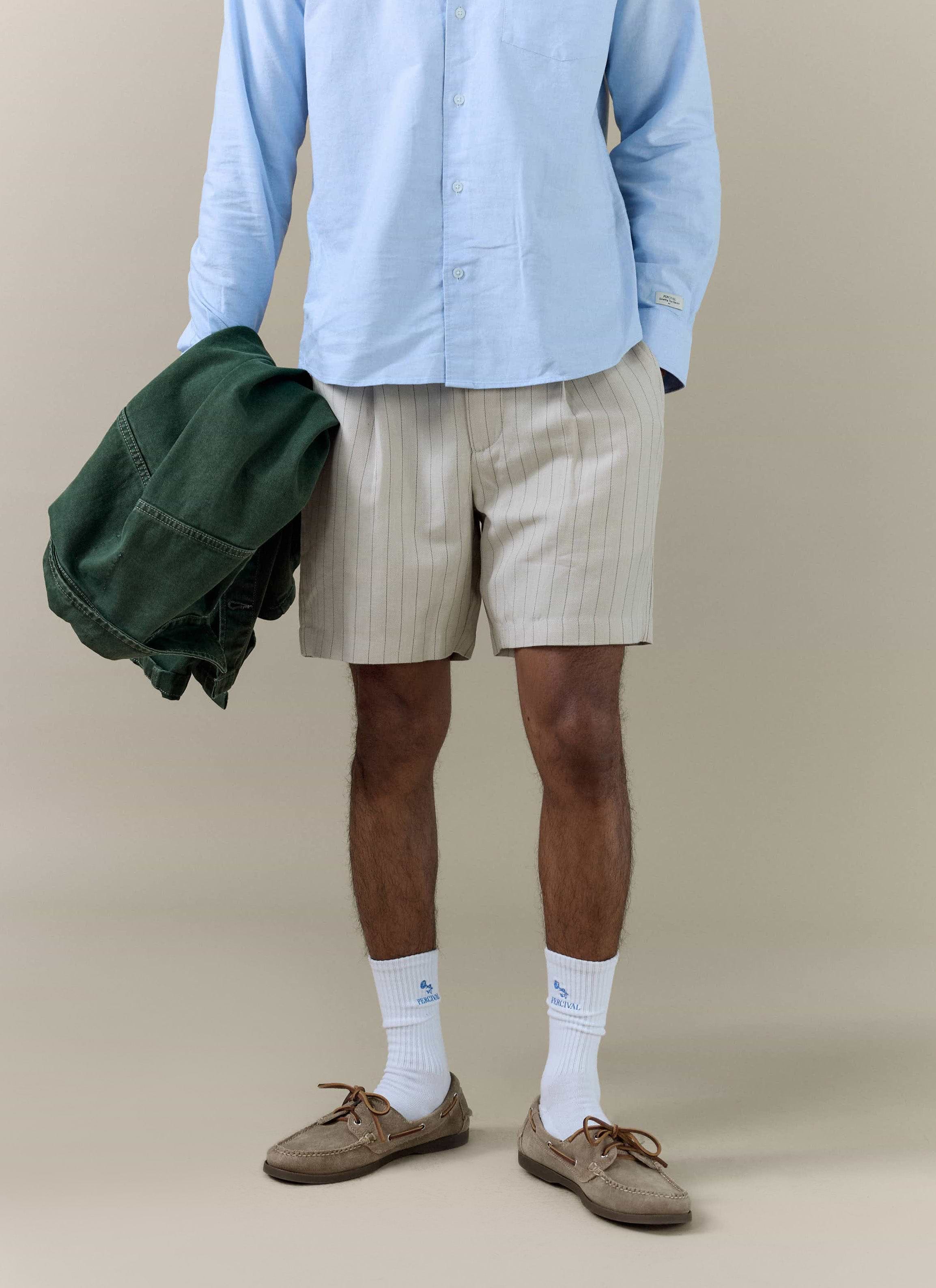 Percival cream striped tailored linen blend shorts styled with a light blue shirt and white branded socks.