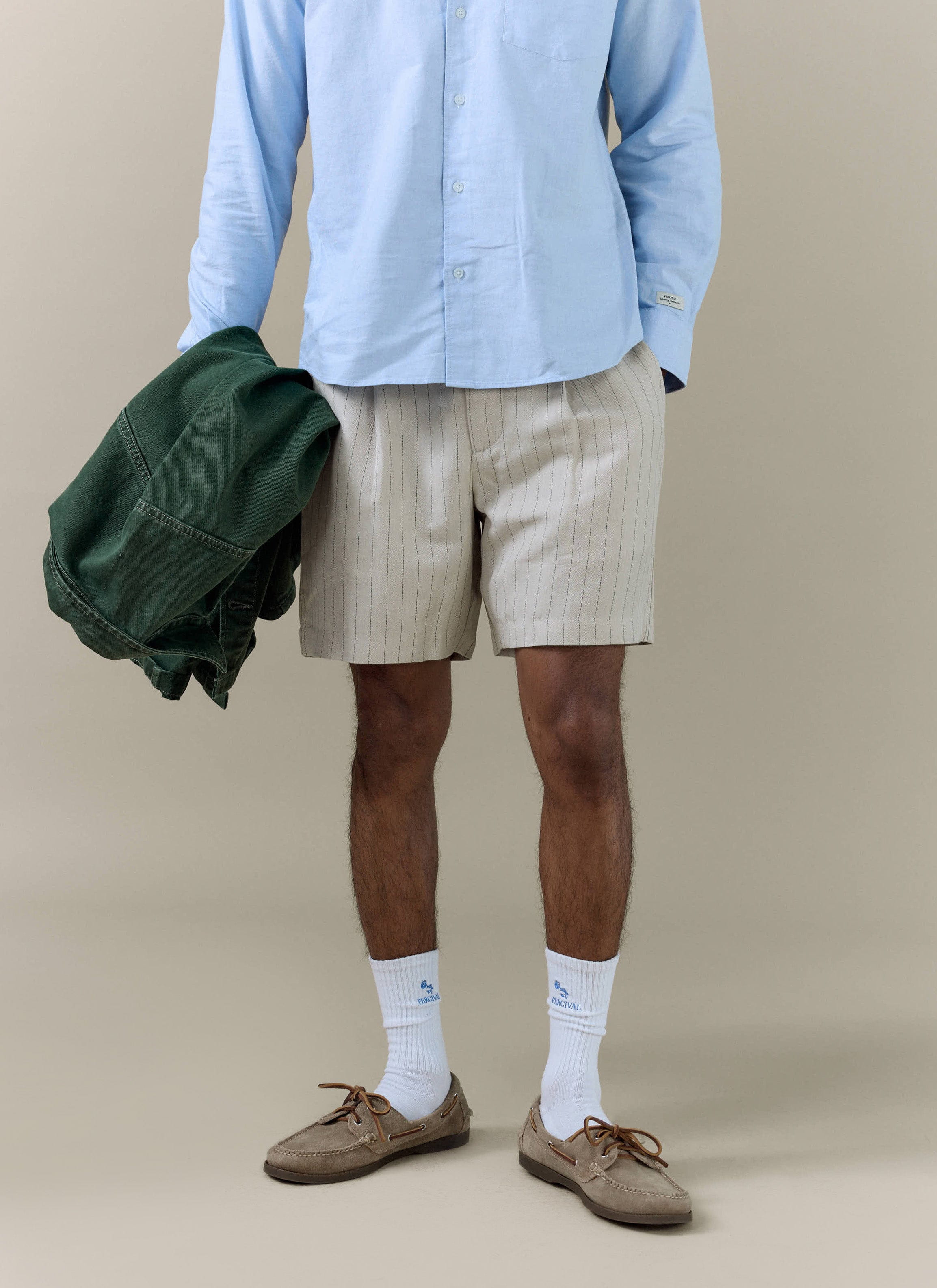 Percival cream striped tailored linen blend shorts styled with a light blue shirt and white branded socks.