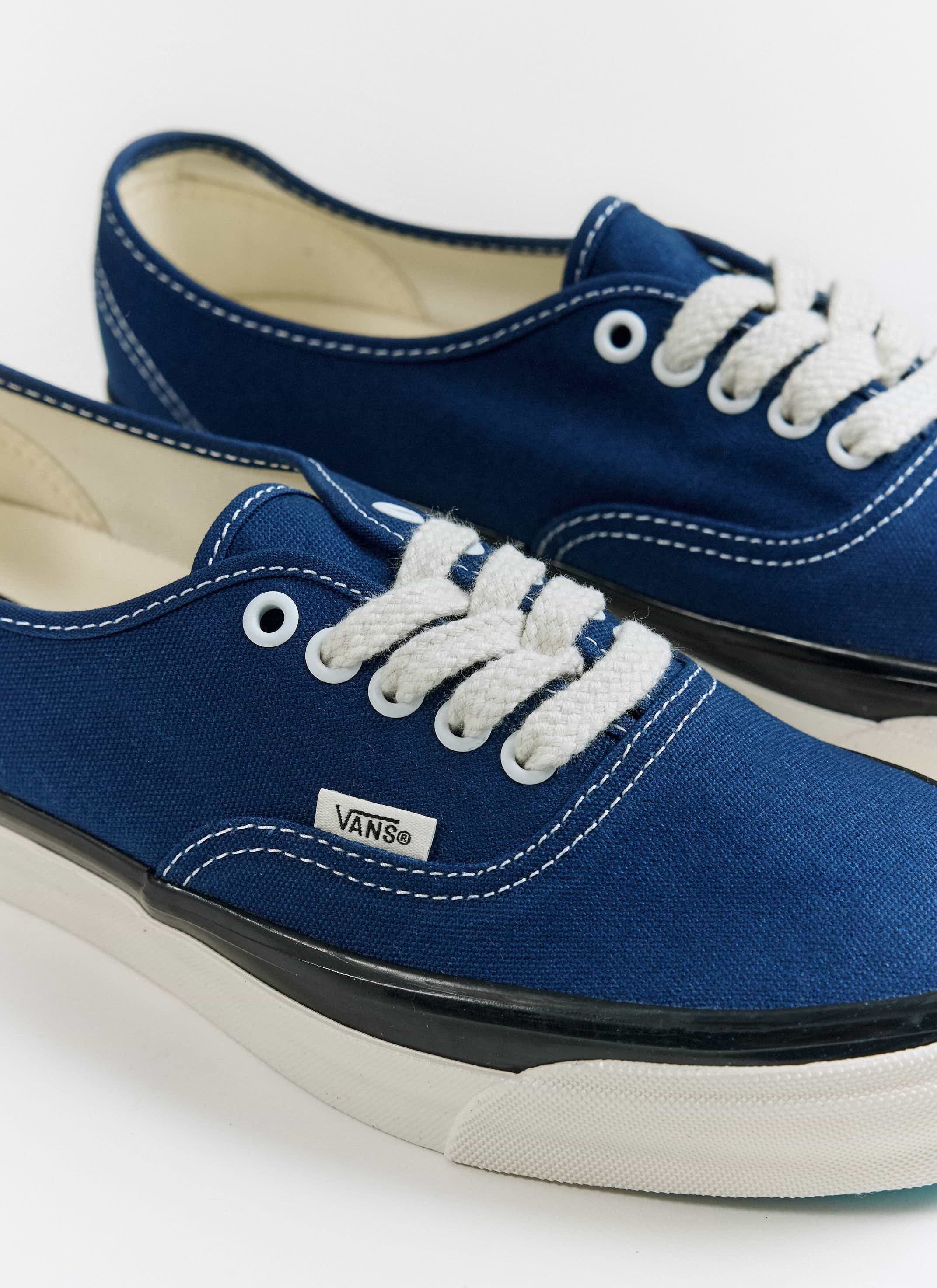 Close-up of the blue Vans Premium Authentic 44 shoes at Percival, showing the canvas upper and white laces.