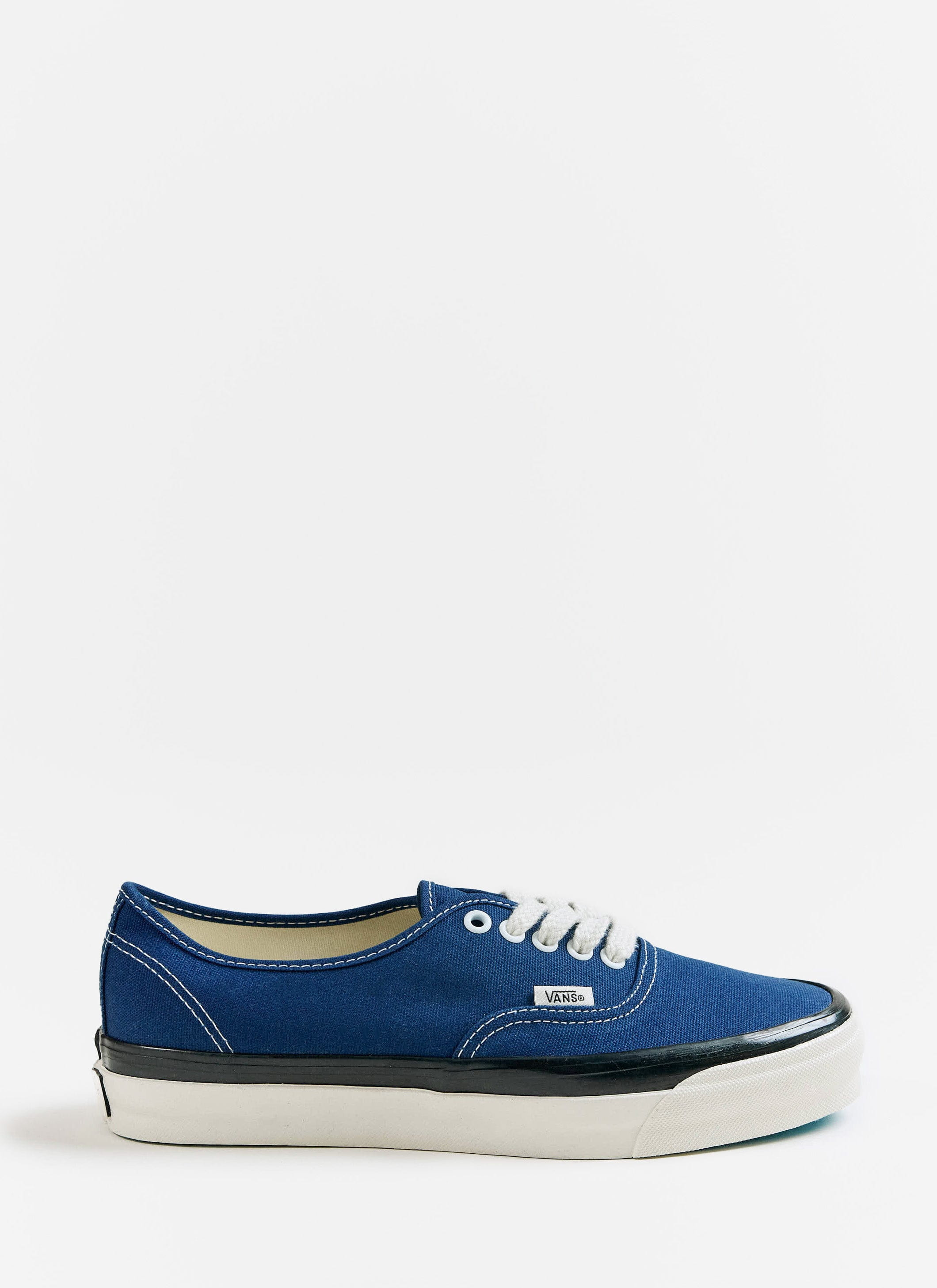 Side profile of the blue Vans Premium Authentic 44 shoes with white laces and a black sidewall, available at Percival.