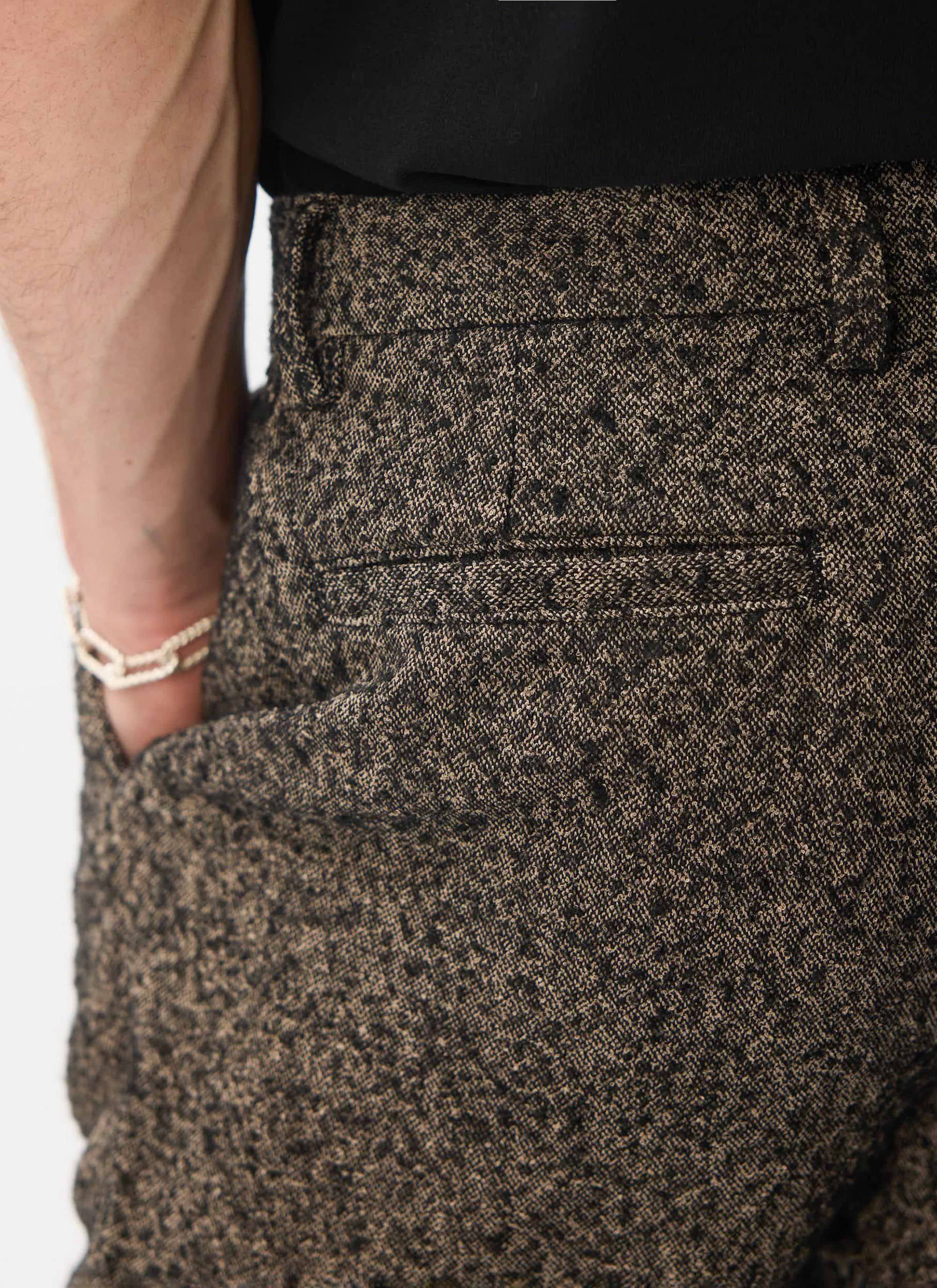 A close-up shot of the back of the Percival Blyton Trousers in grey, highlighting the warm nep blend fabric and jet pocket.