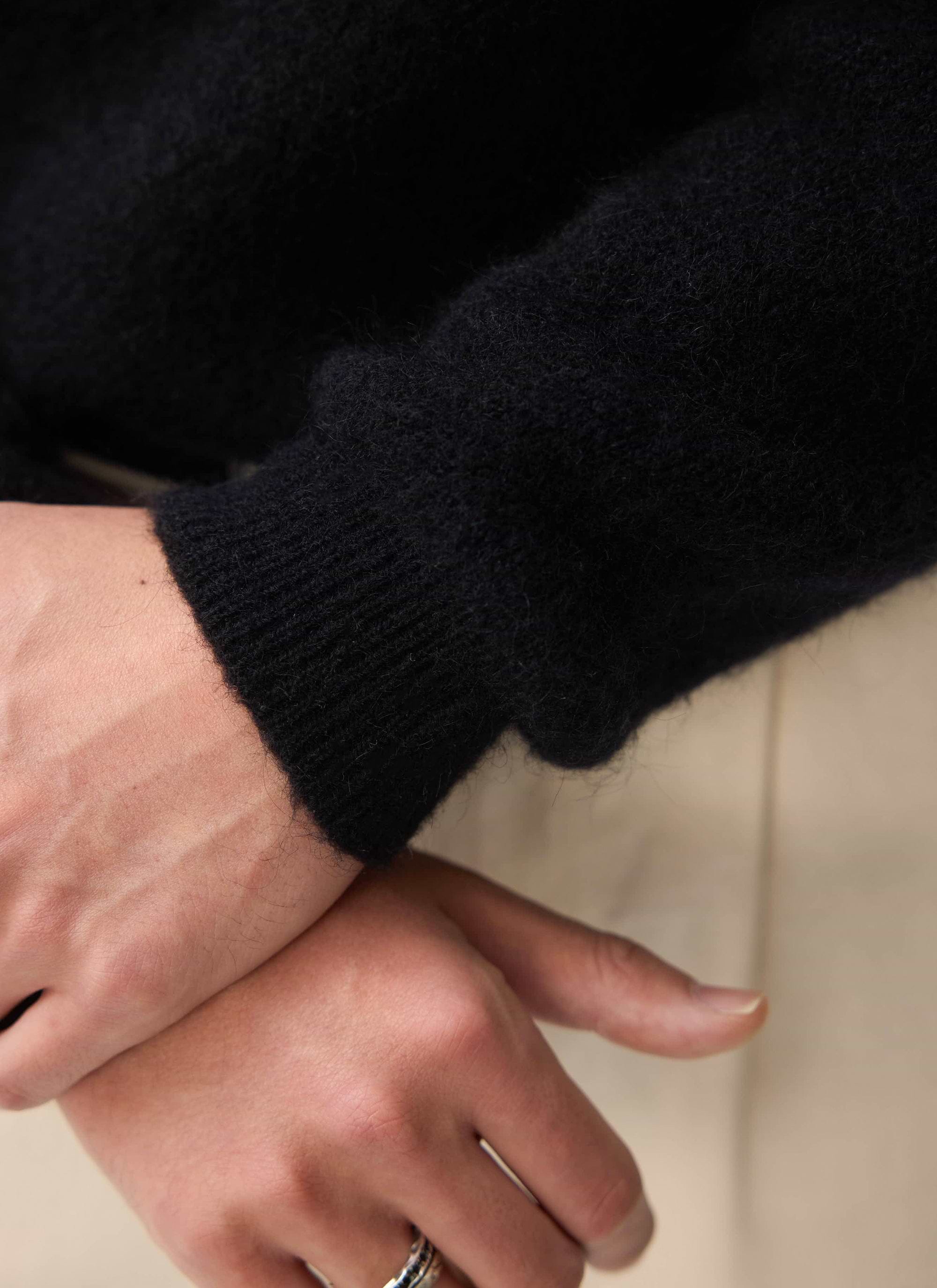 A close-up of the ribbed cuff and soft mohair texture of the black White Glove Crew Neck Jumper from Percival.
