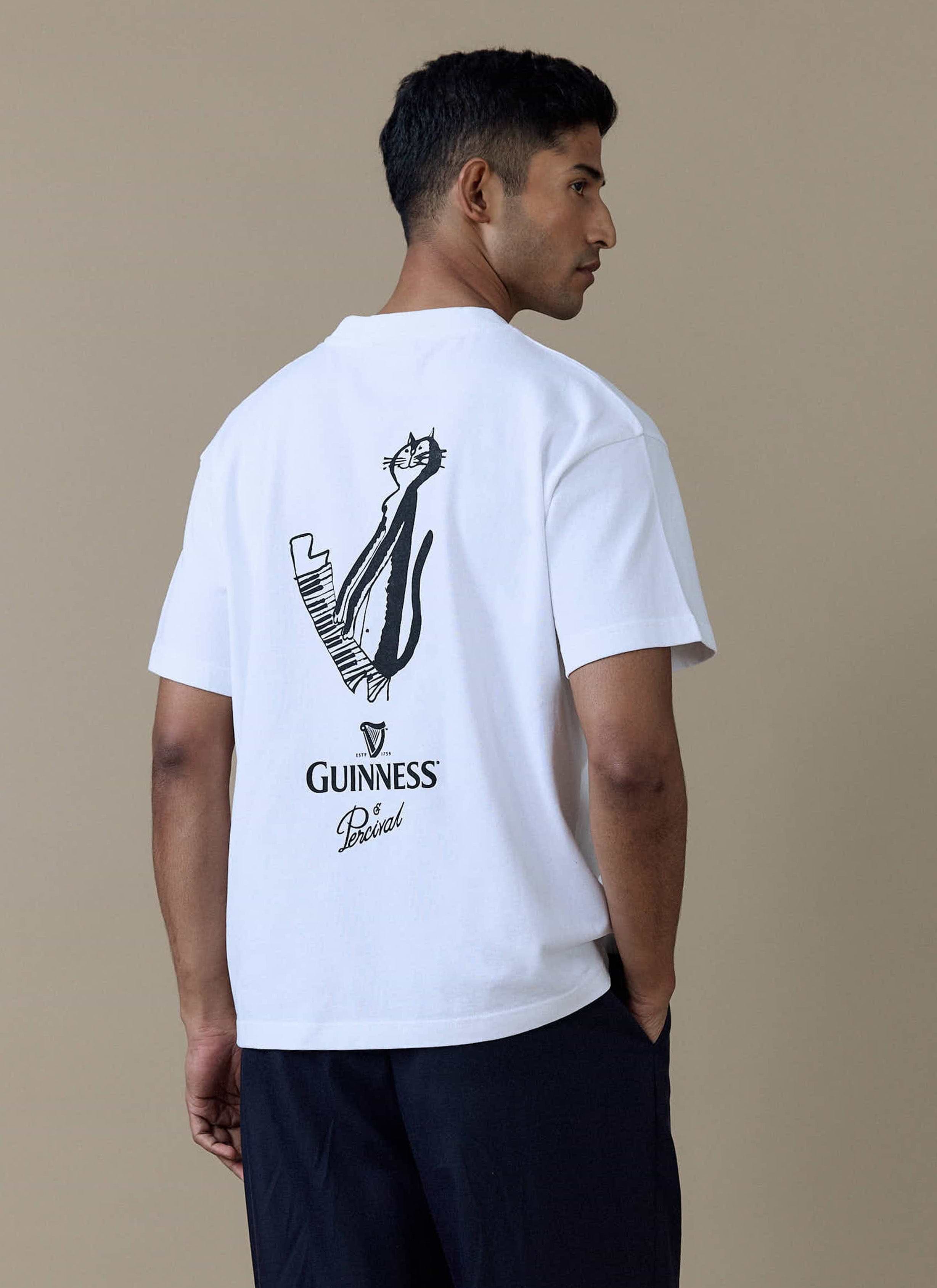 Back view of a model wearing the white Percival x Guinness oversized t-shirt with a cat playing a piano illustration.