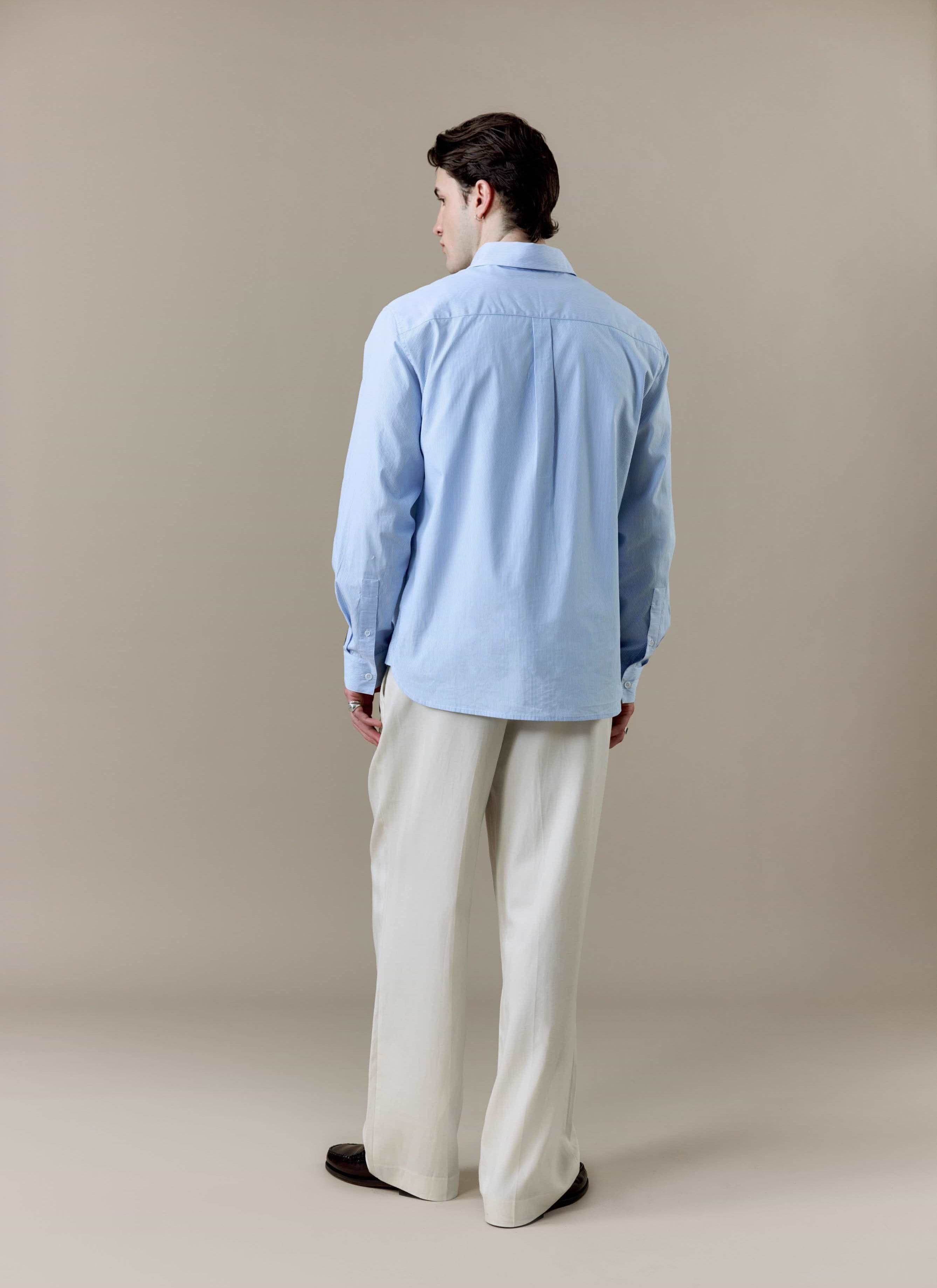 A full-length back view of a model wearing the Percival x Brighton & Hove Albion F.C. Striped Pearce Long Sleeve Shirt.