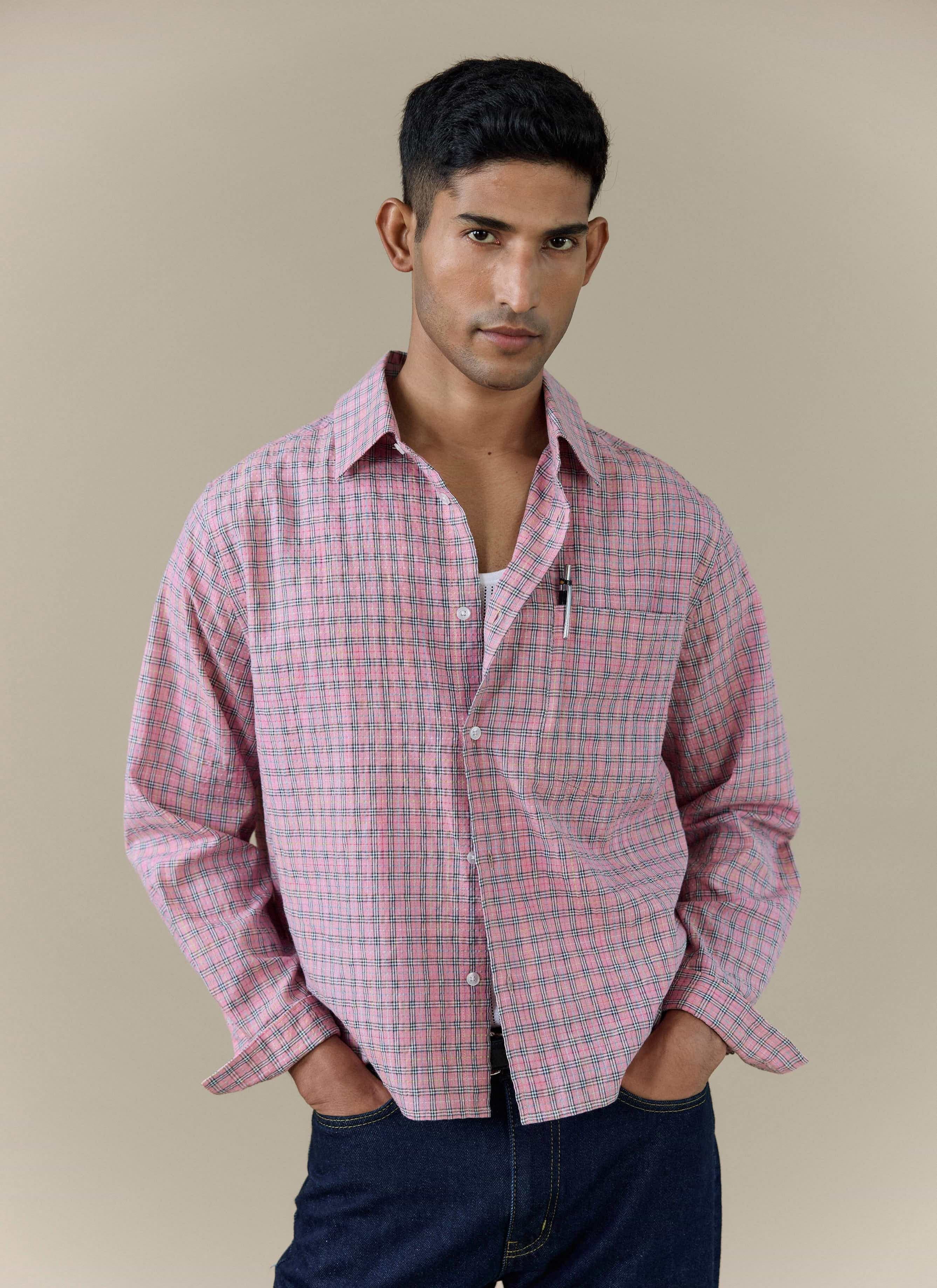 A model wearing the pink checked Hinsley Boxy Shirt by Percival, styled with dark denim jeans.