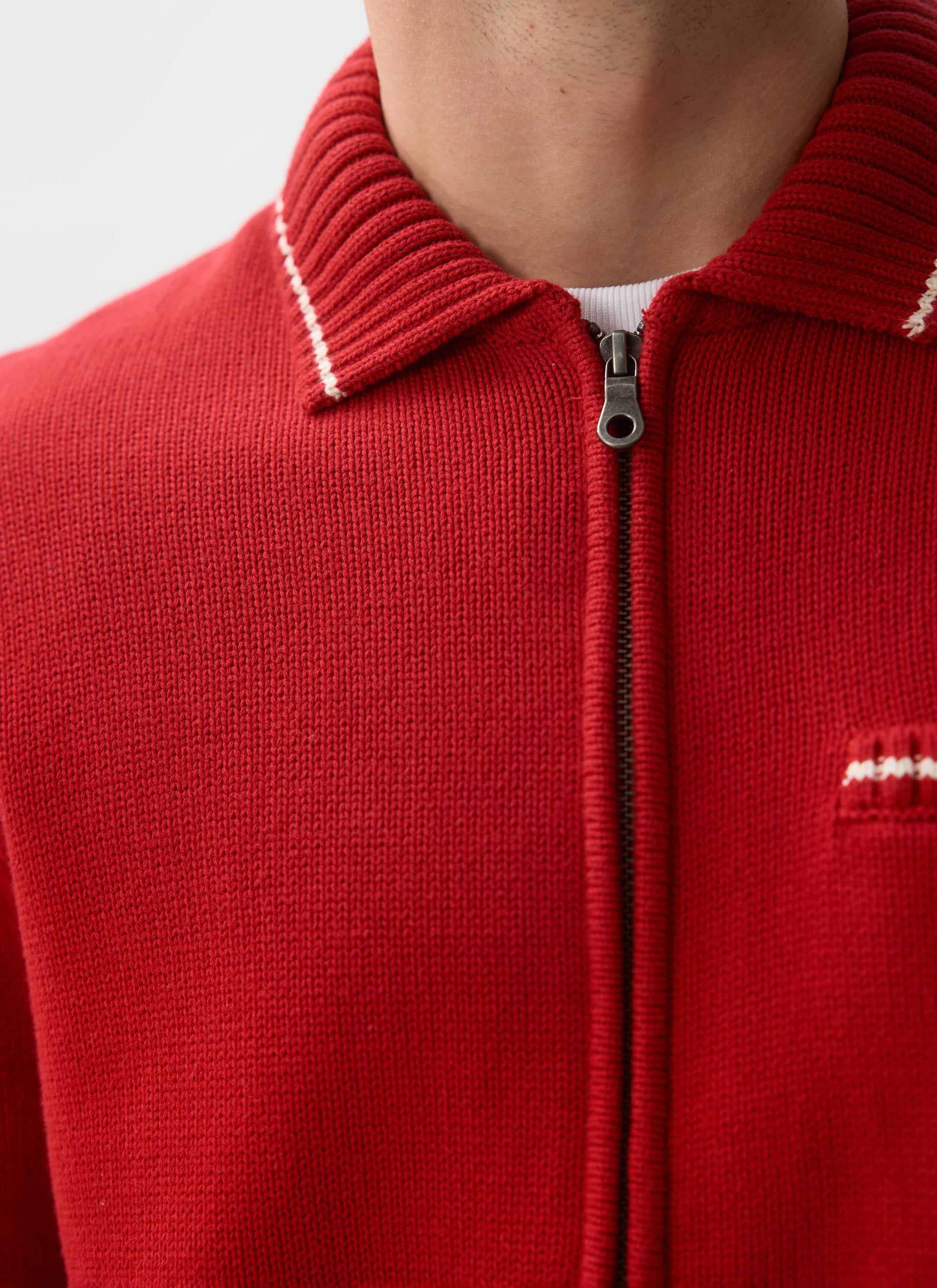 Close-up of the Percival Gardner Zip Cardigan in red, showing the dense cotton knit, contrast stitch collar and zip detail.