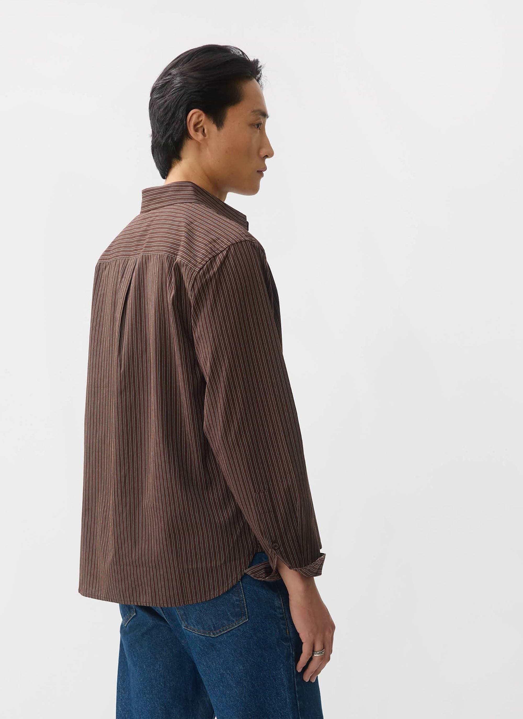 Back view of a model wearing the Percival Clancy Striped Long Sleeve Shirt in brown, paired with classic blue jeans.